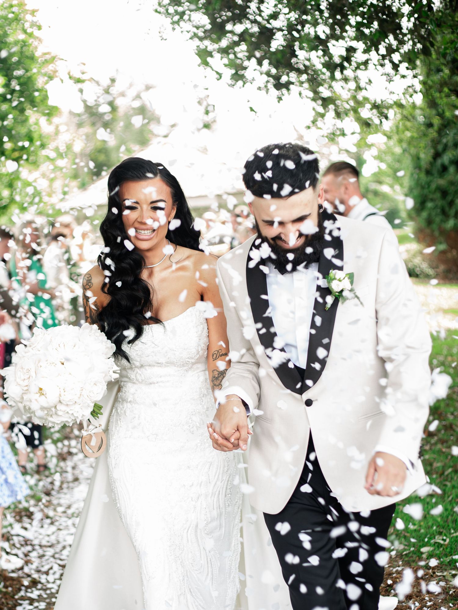 Newlyweds celebrate with confetti and joyful embraces in the grounds of Avisford Park Hotel.