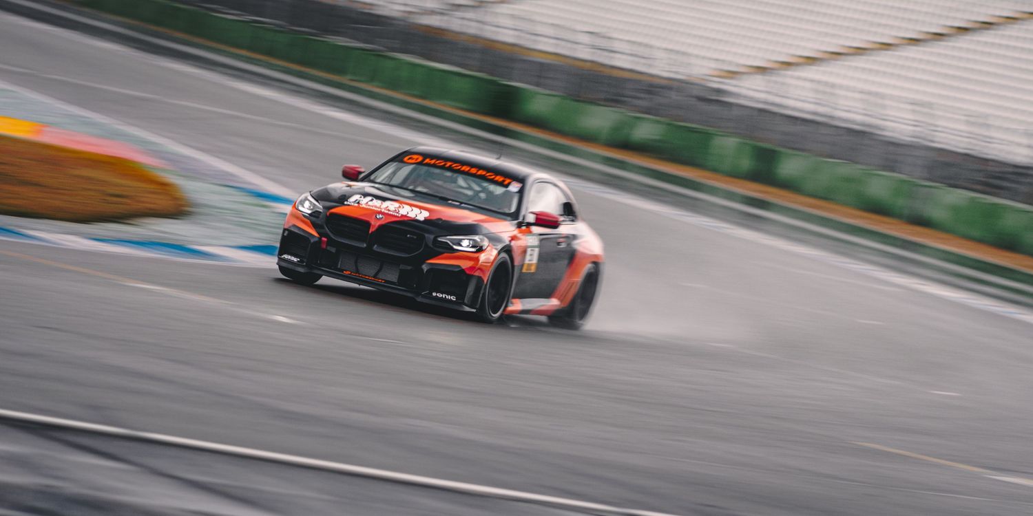 Race cars competing at high speeds on a professional motorsport circuit.