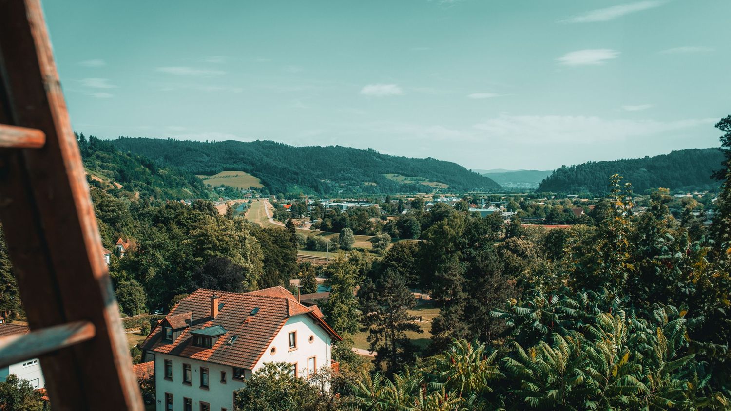Panoramic view of hillside homes and mountains in European countryside.