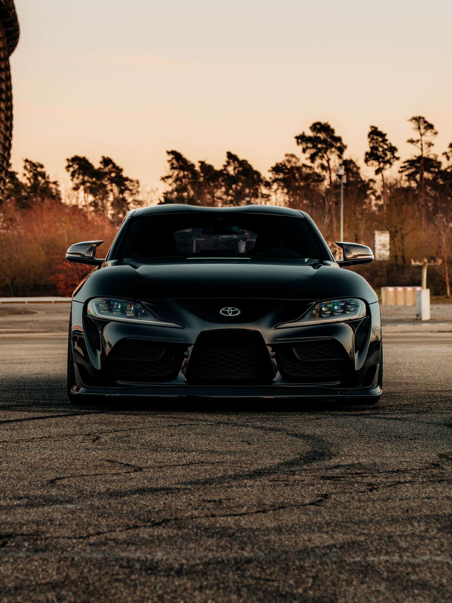 Low angle view of performance cars silhouetted against a warm sunset sky.