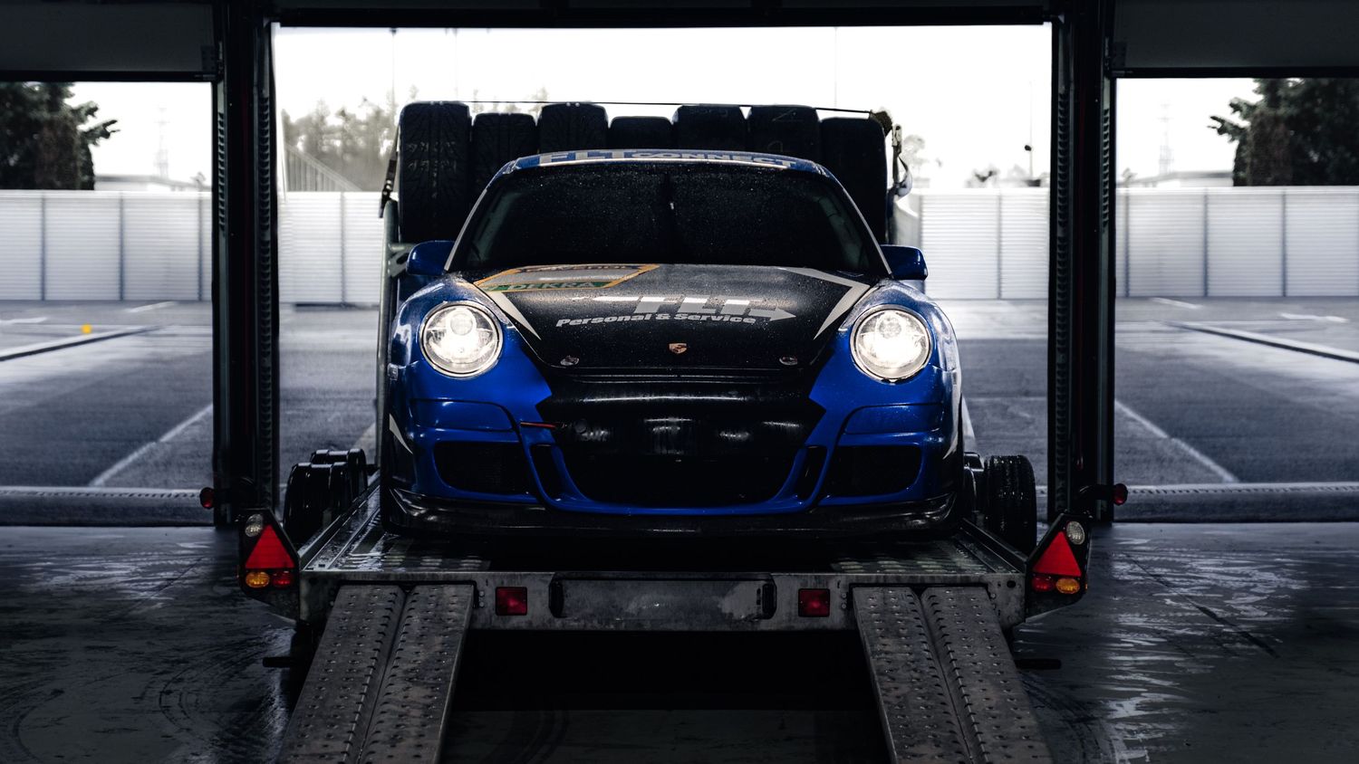 Racing cars in garage showing dramatic headlights and front profiles.