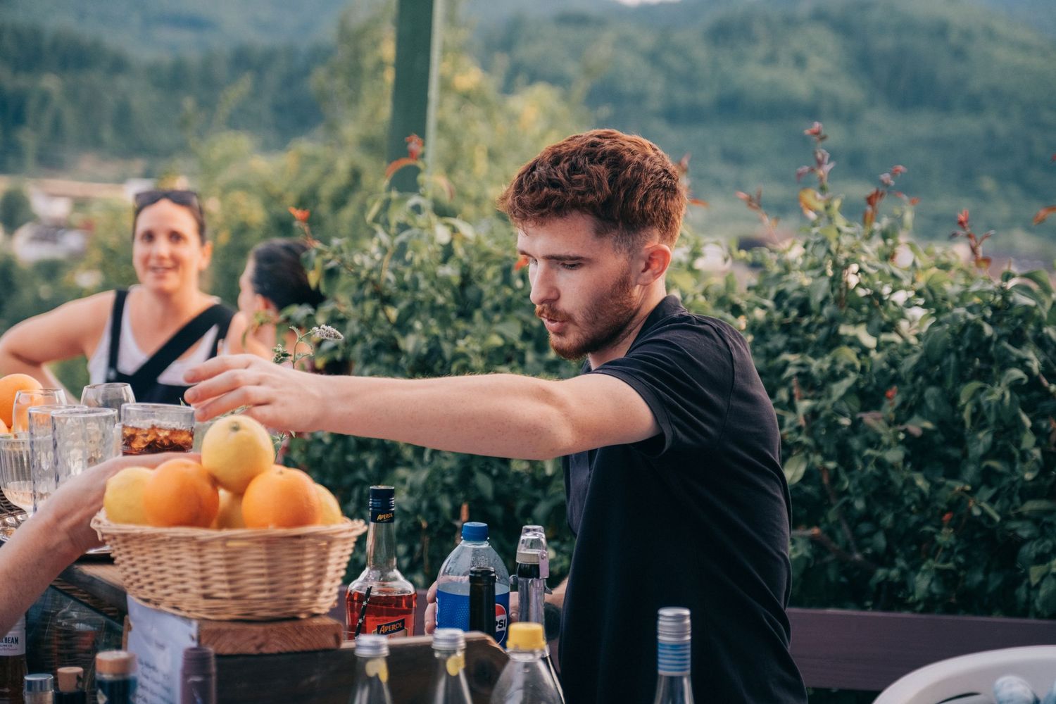 Outdoor party setup with fresh fruit and drinks on a scenic terrace.