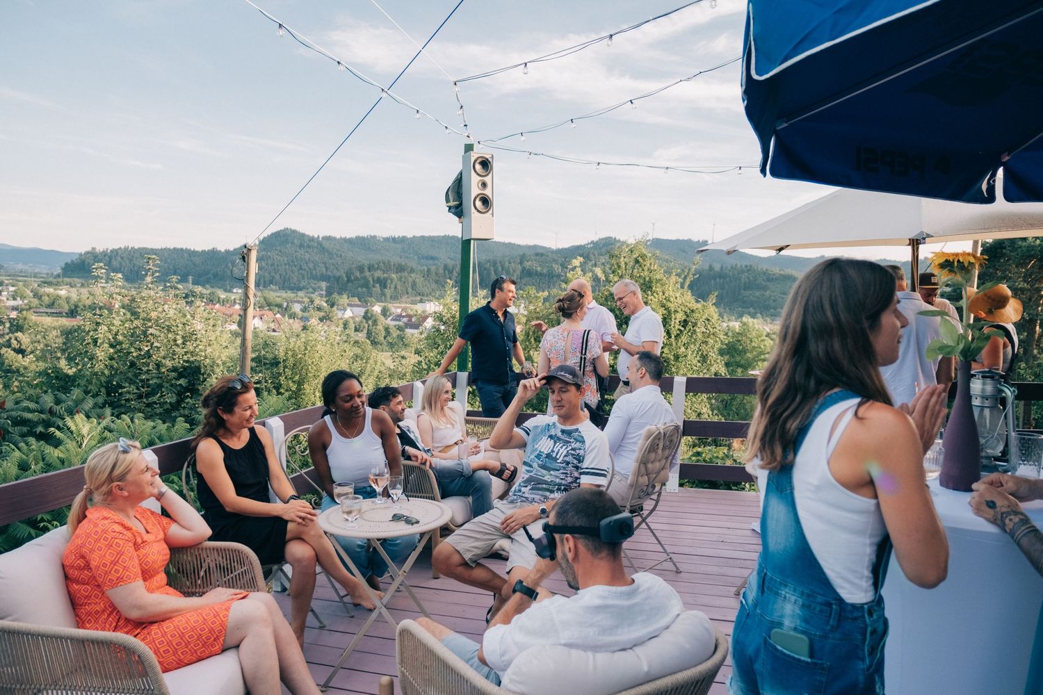 Guests relaxing under umbrellas on a scenic mountain terrace.