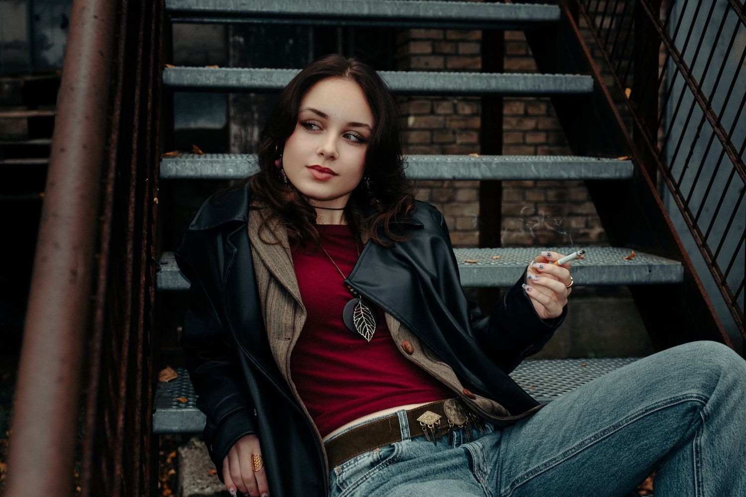 Urban photoshoot on brick steps with leather jacket and casual styling.