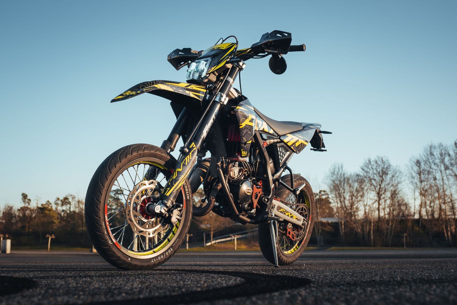 Low angle view of dirt bikes silhouetted against blue sky at dusk.