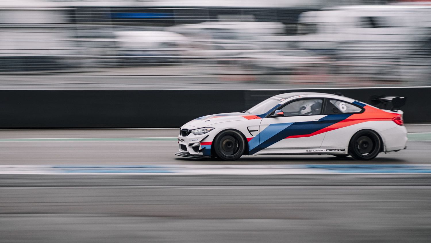 High-performance race cars speeding along a racetrack with motion blur effect.