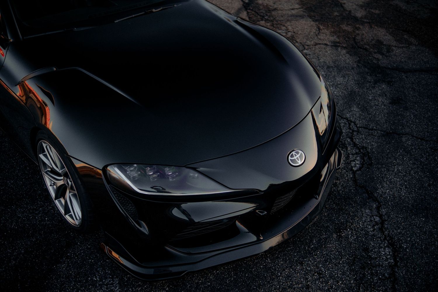 Close-up front view of a black Toyota Supra showing aggressive styling and headlight details.