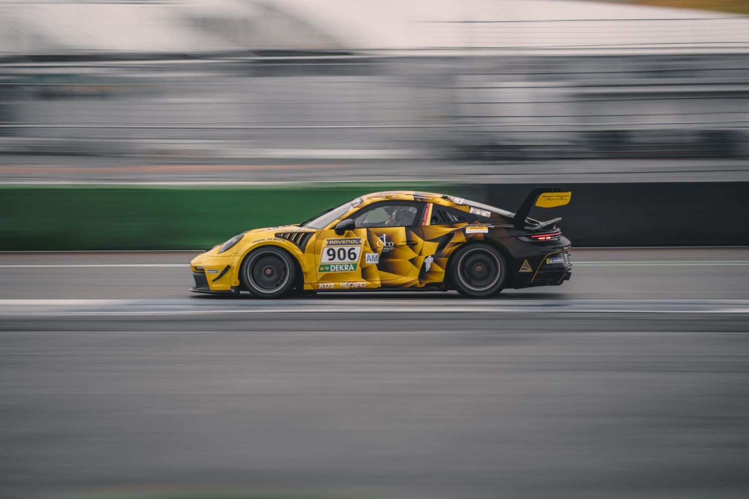 Yellow and blue race cars racing at high speed on a motorsport track.