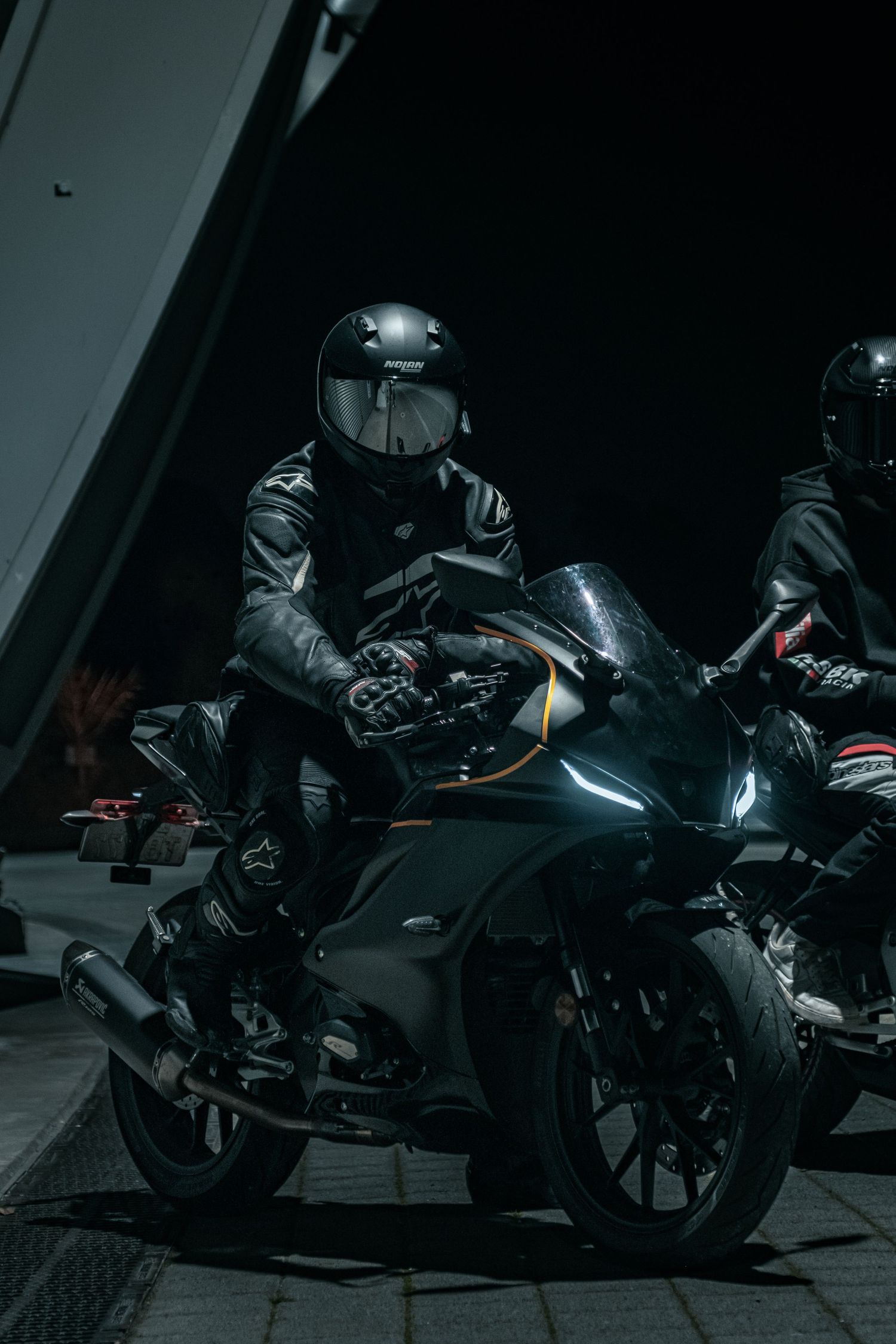 Motorcycles arranged in moody low-key lighting with dramatic shadows.