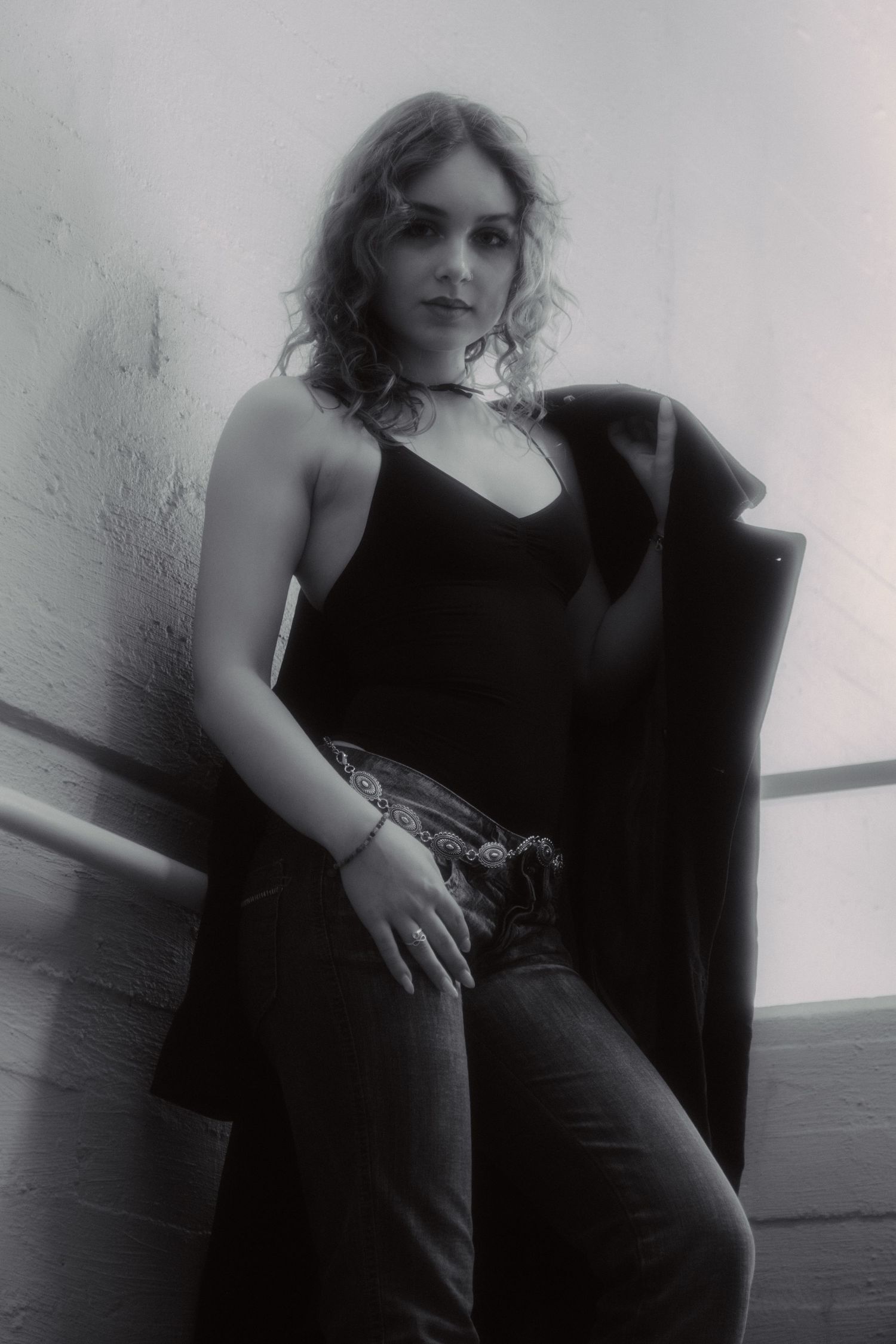 Black and white portrait series showing elegant poses in dark clothing against light background.