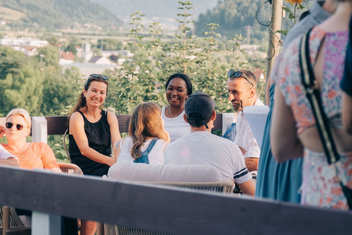 People gathered at an outdoor venue with mountain views during a social event.