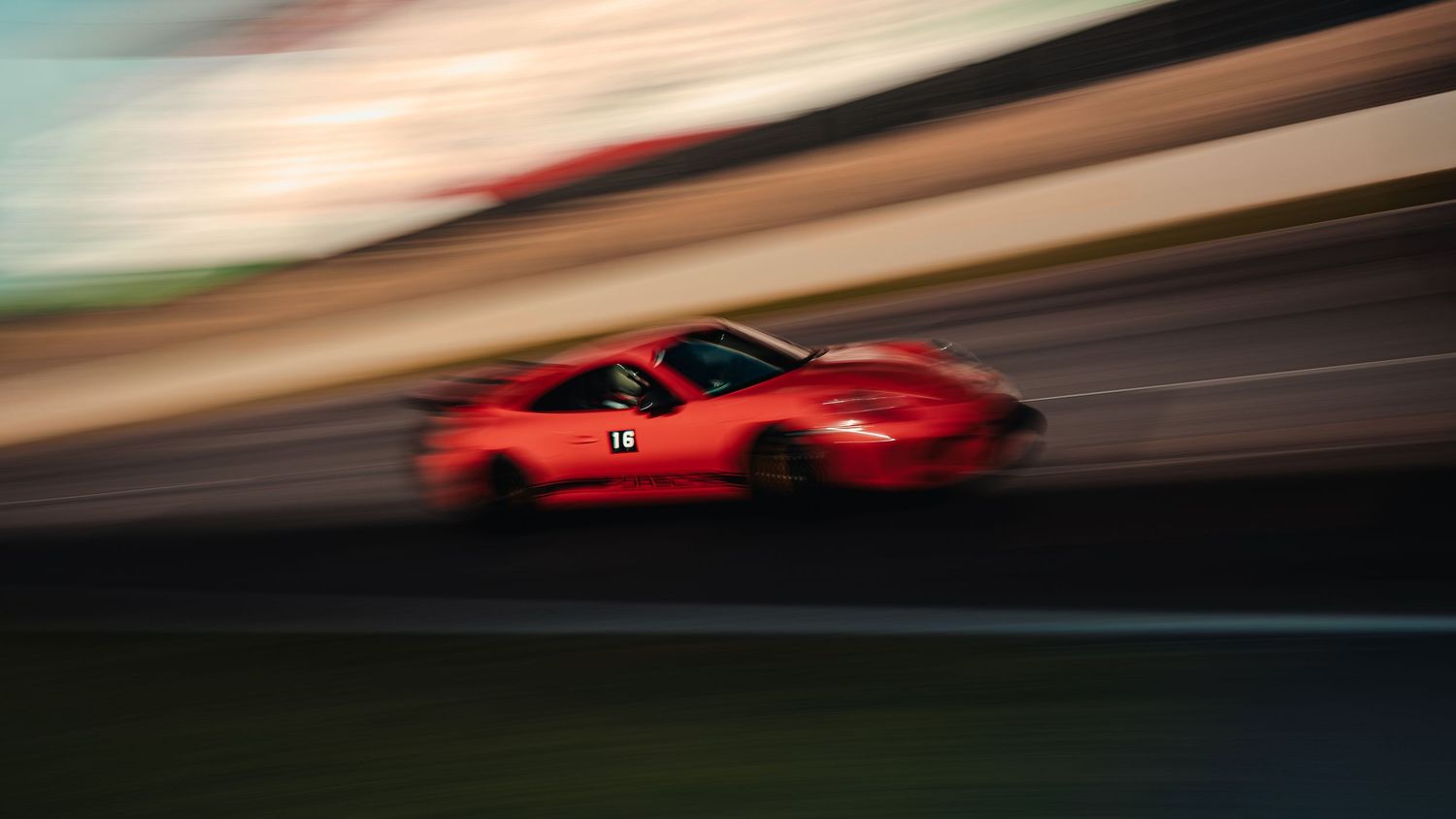 Red sports car speeding on a race track with motion blur effect photography.
