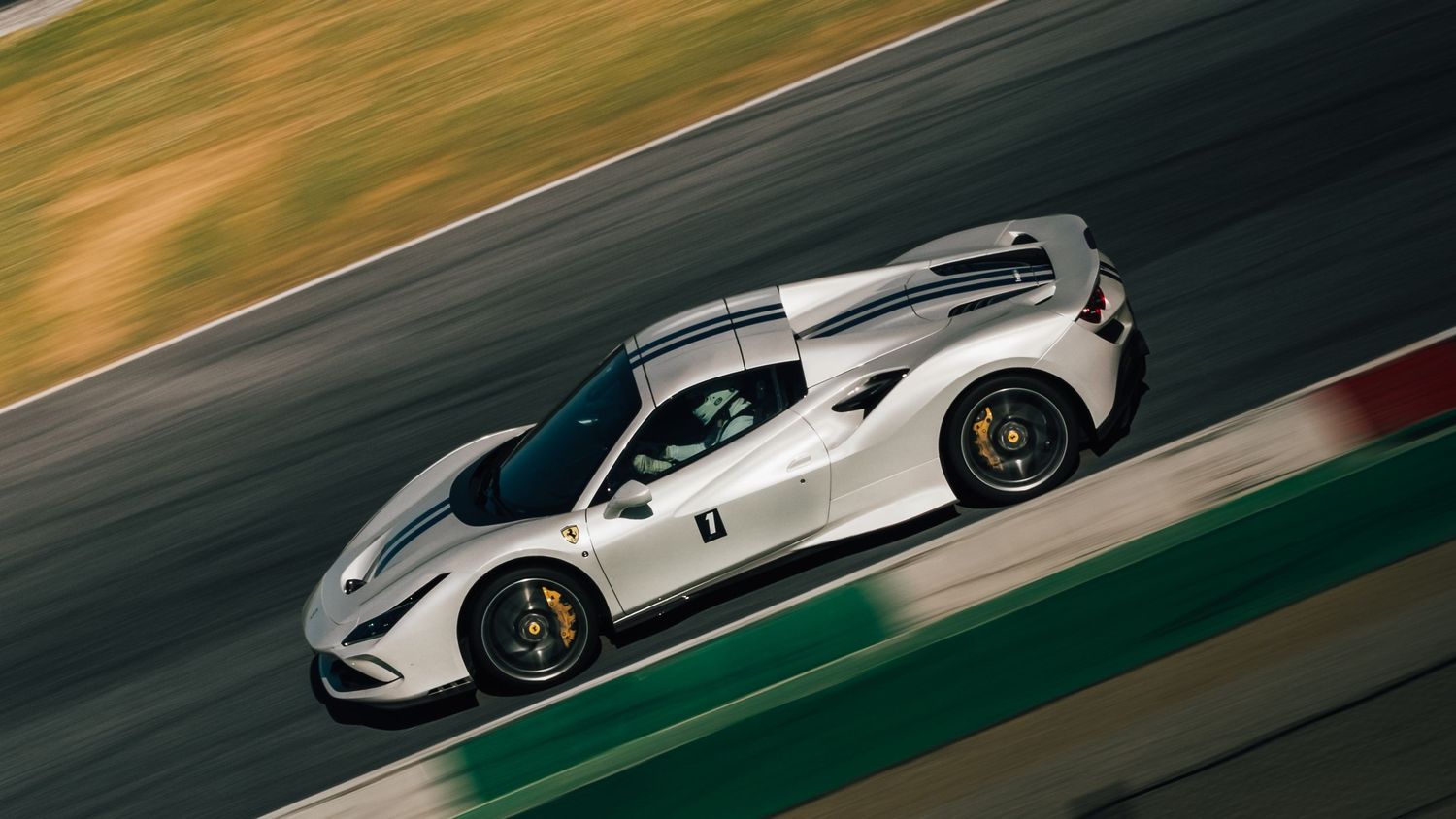 White Ferrari 488 Pista supercar racing on a track, captured from above at high speed.
