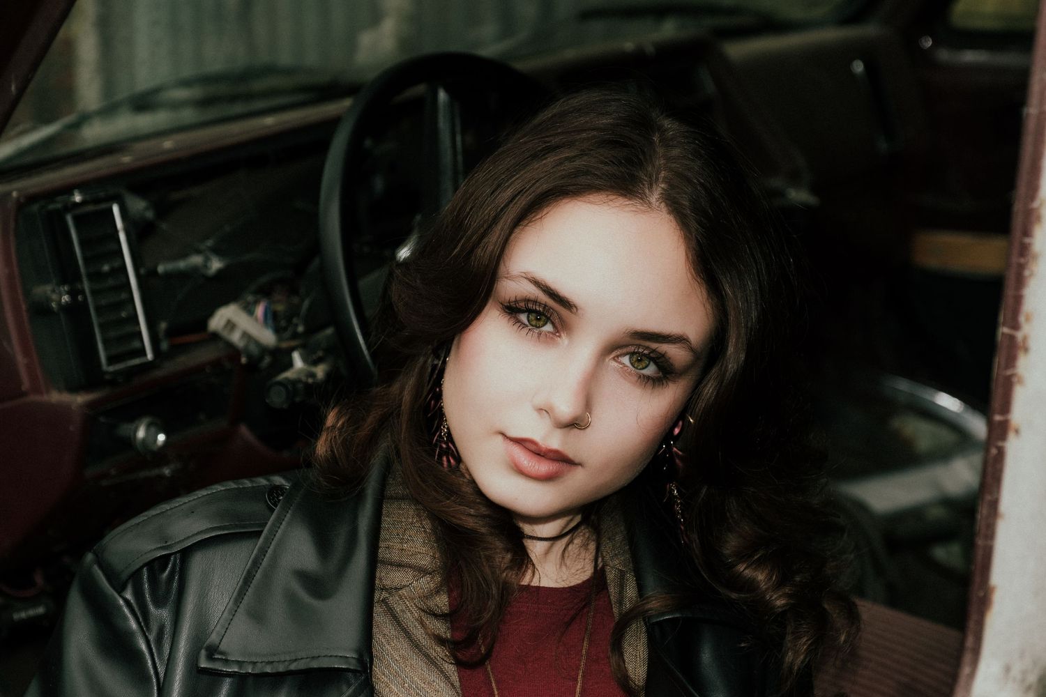 Artistic portrait in dark tones featuring red lipstick and dramatic shadows.
