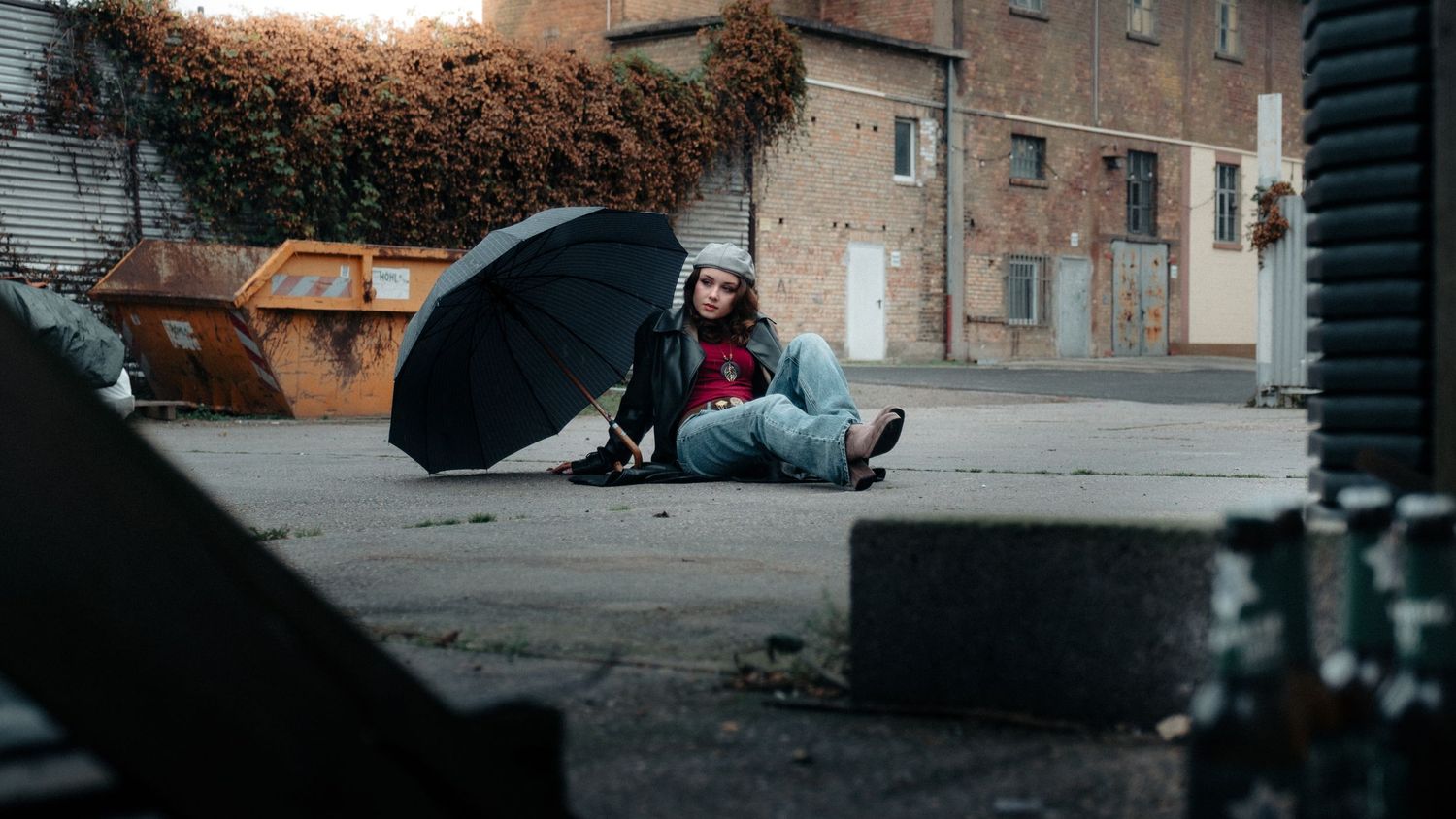 Dramatic urban scene with brick buildings and dark shadows creating moody atmosphere.
