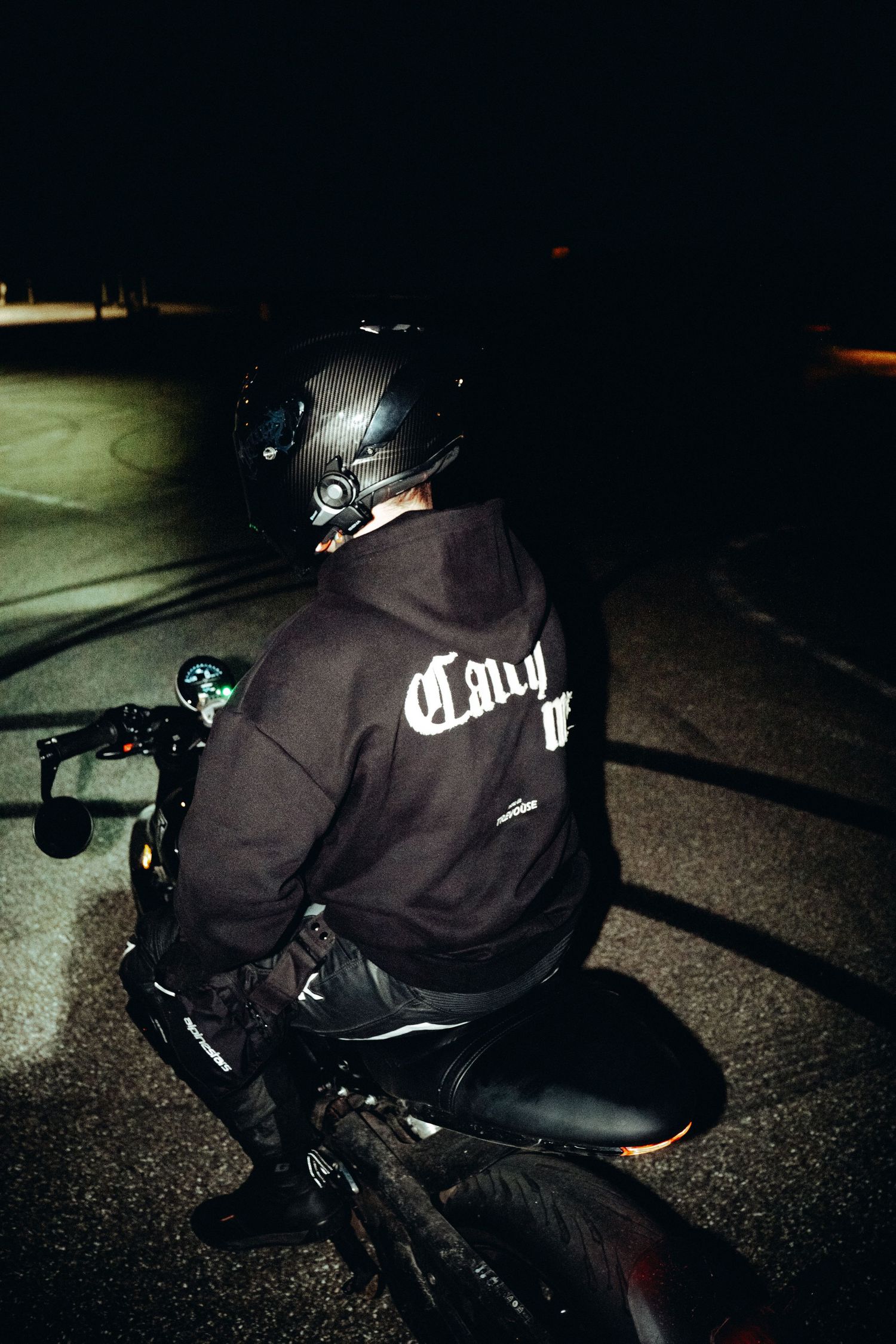 Night photography sequence of person on motorcycle in dark parking lot.