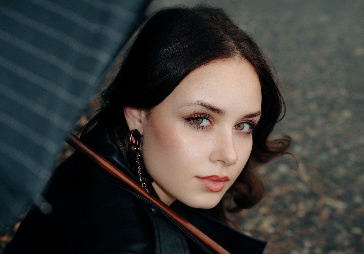 Dramatic close-up portrait with dark tones and moody lighting.