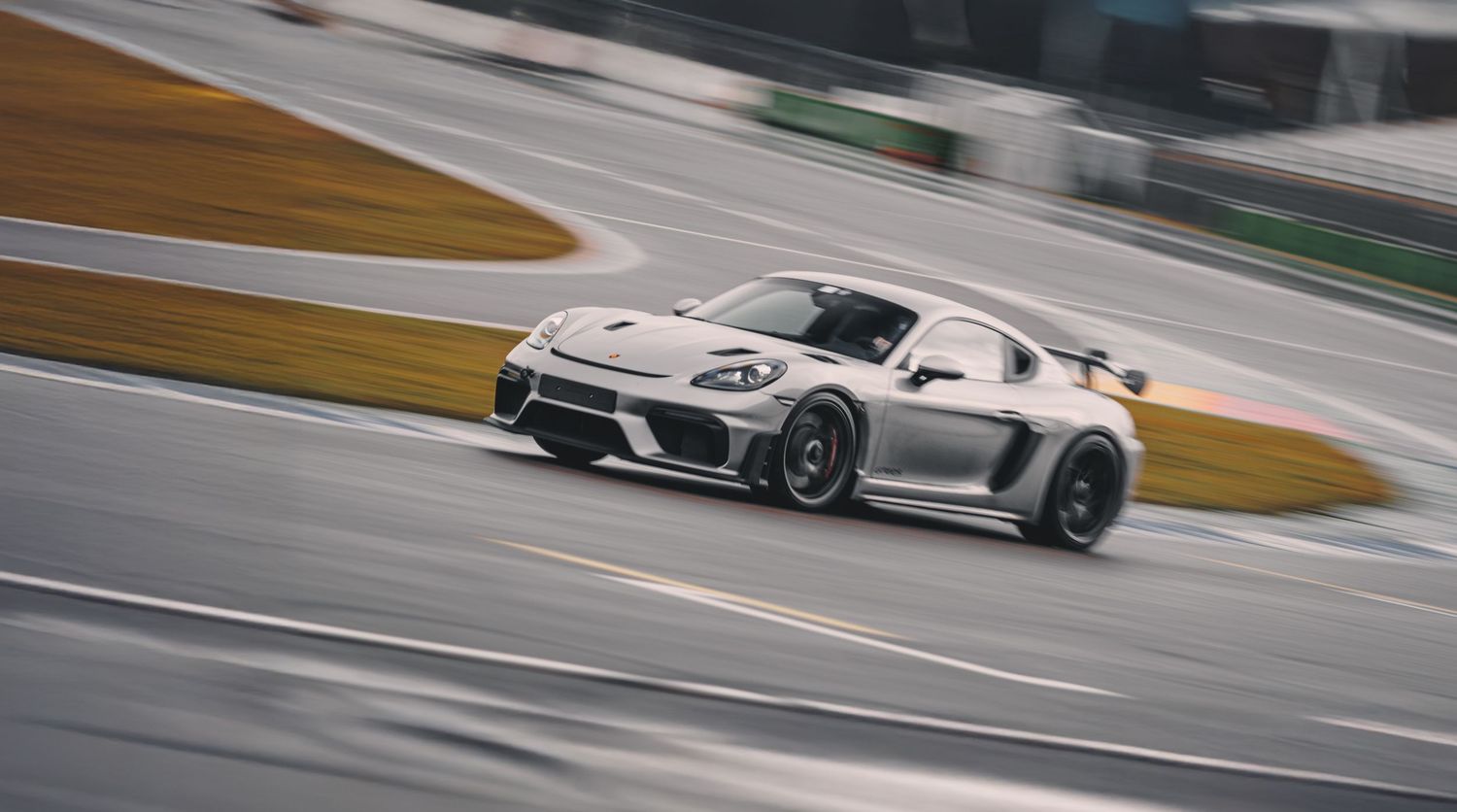 Racing cars competing on a professional circuit with dramatic motion blur.