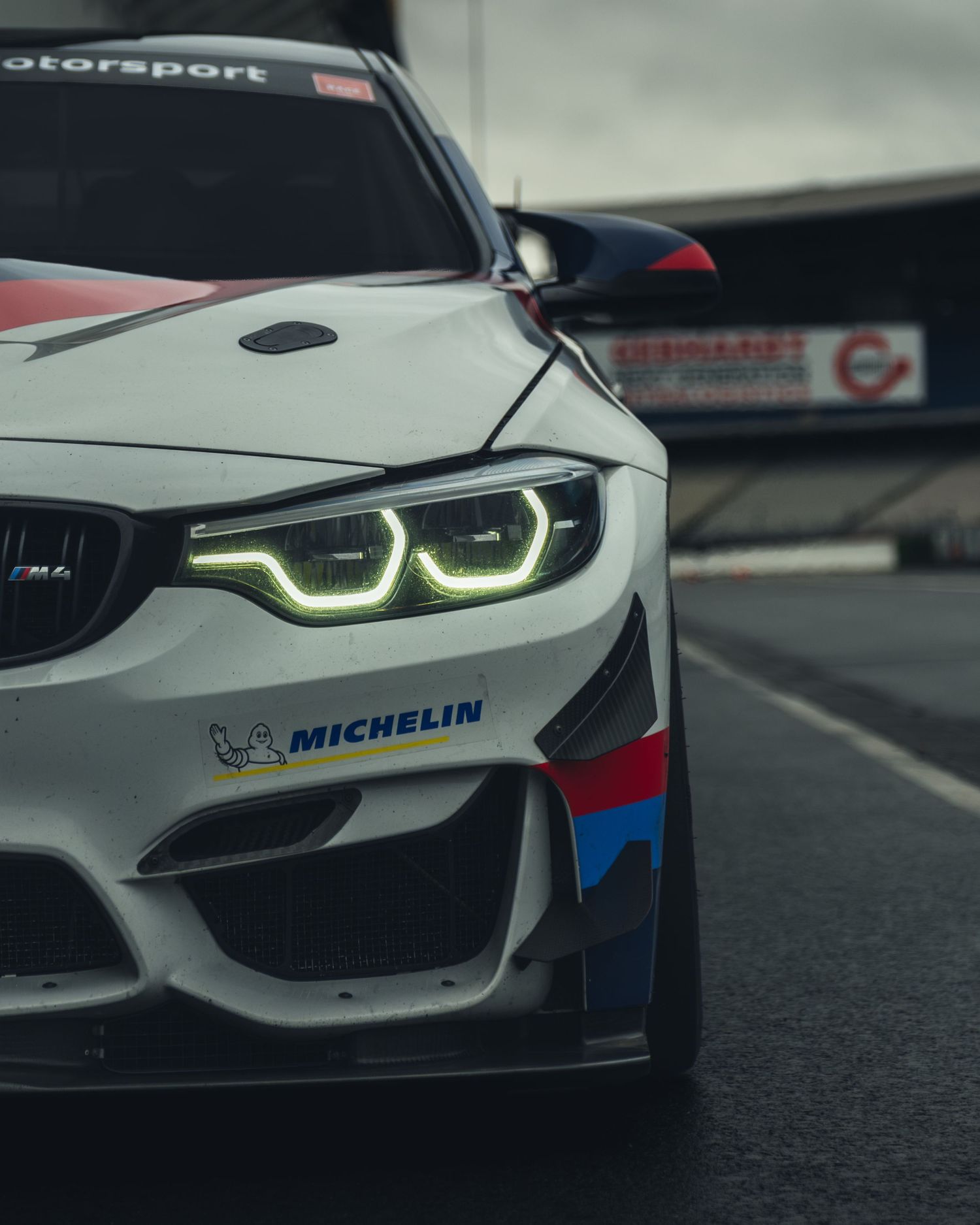 BMW motorsport vehicle headlight detail showing distinctive LED lighting design.