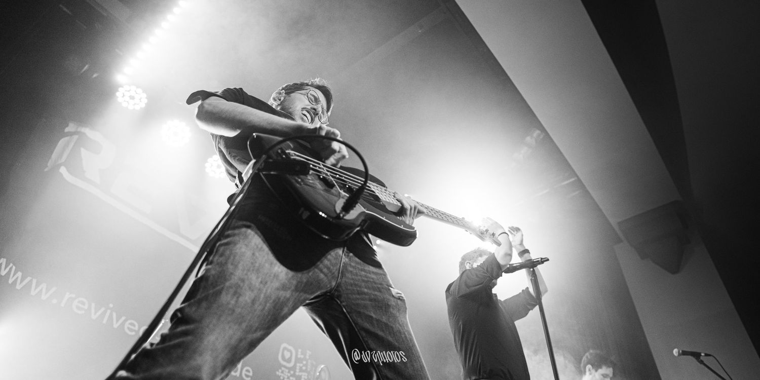 High contrast black and white stage performance with dramatic spotlighting.