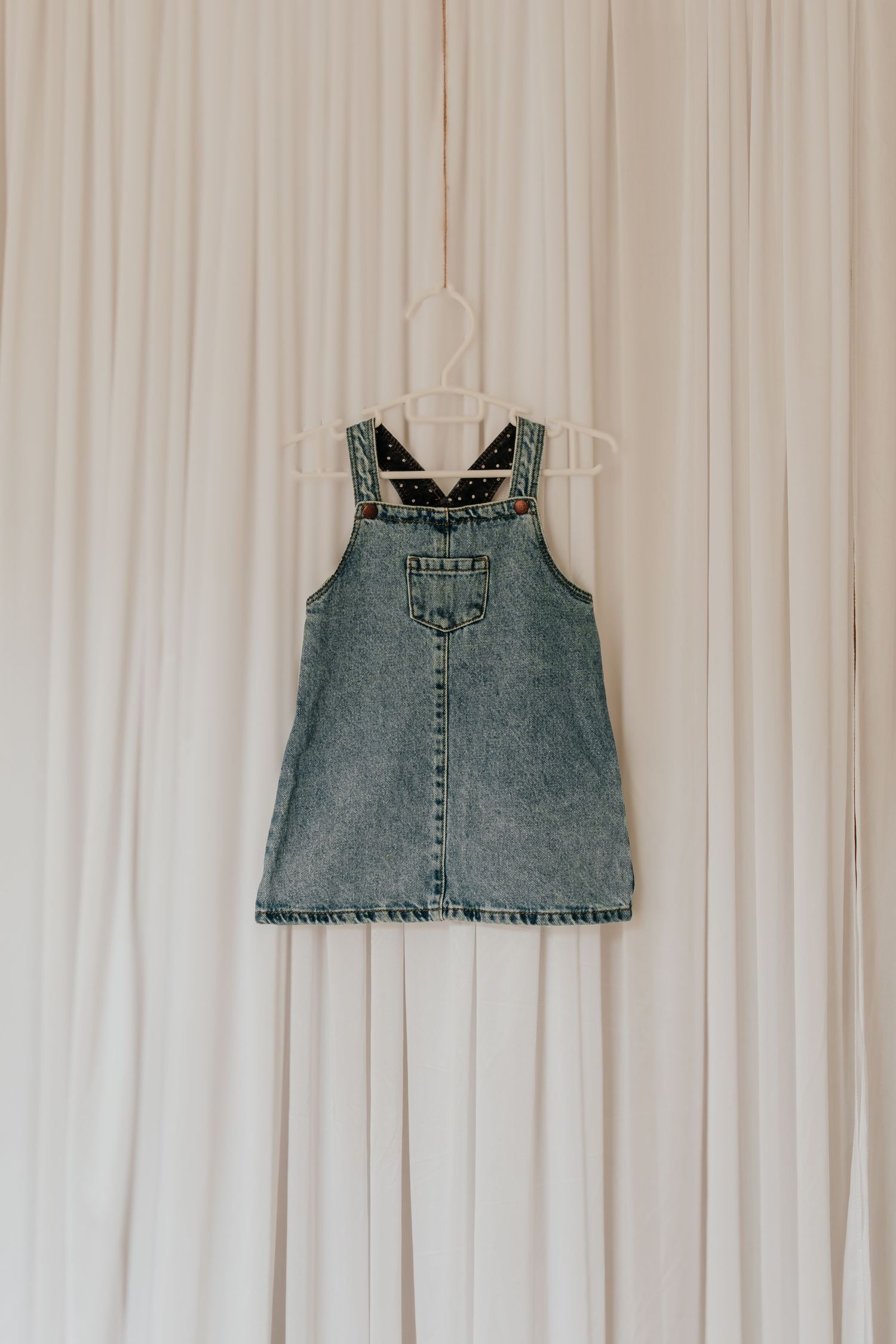 Denim-Crop-Tops aus Upcycling-Jeans, die in einer Reihe vor einem weißen Vorhanghintergrund angeordnet sind.