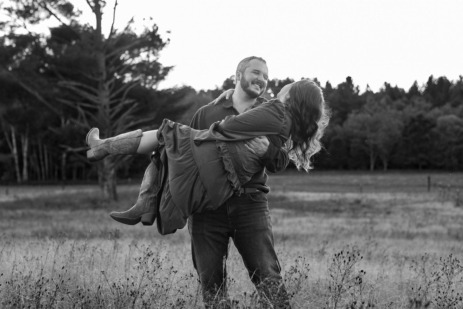A black and white photo sequence shows a couple performing a playful dance lift movement in a grassy field.