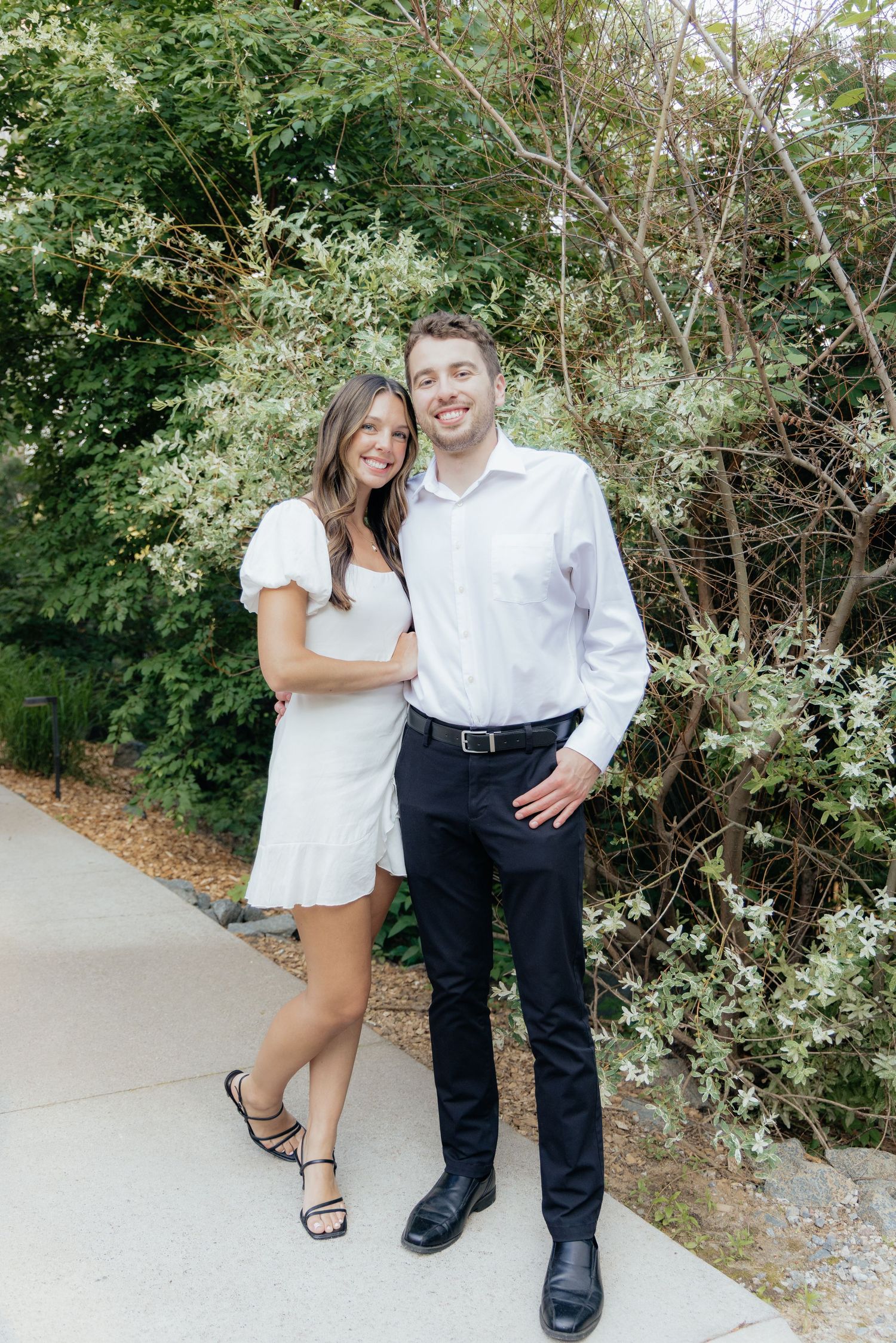 Golden-hour portrait of a couple embracing among tall trees at Pinewood in Cambridge, showcasing woodsy elegance.