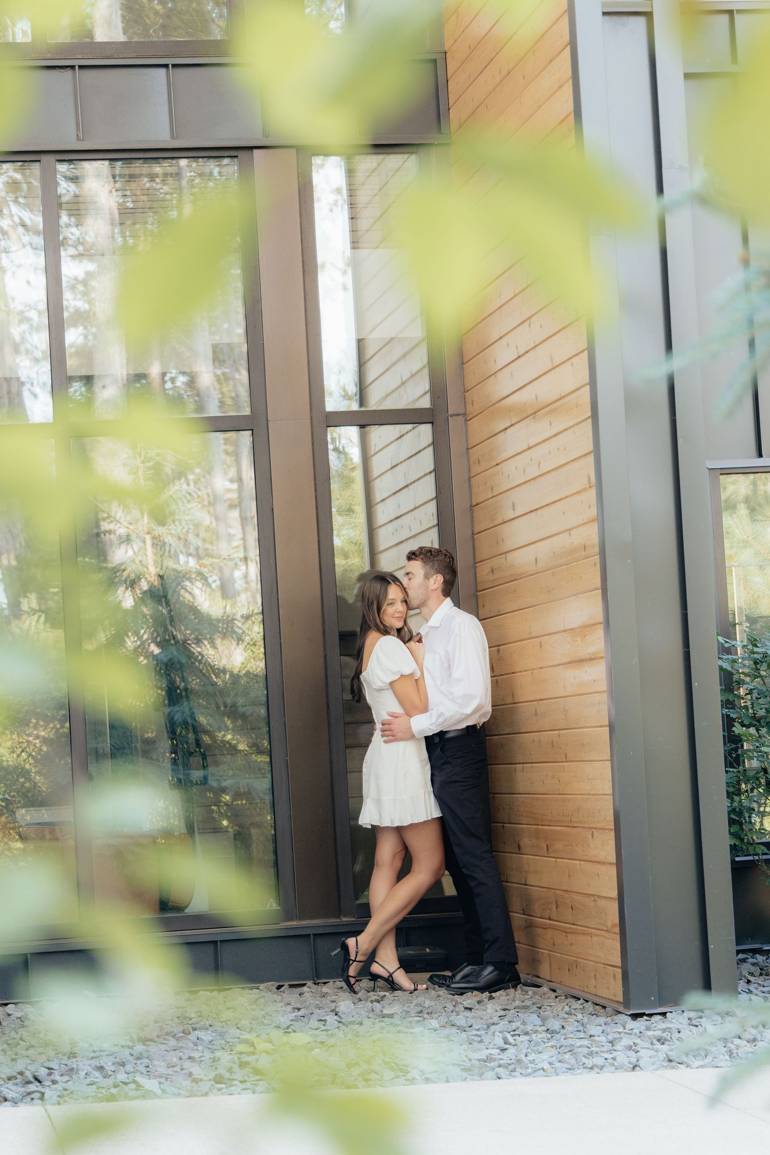 Moody and romantic couples photo with the Pinewood venue softly blurred in the background, highlighting emotion and connection.