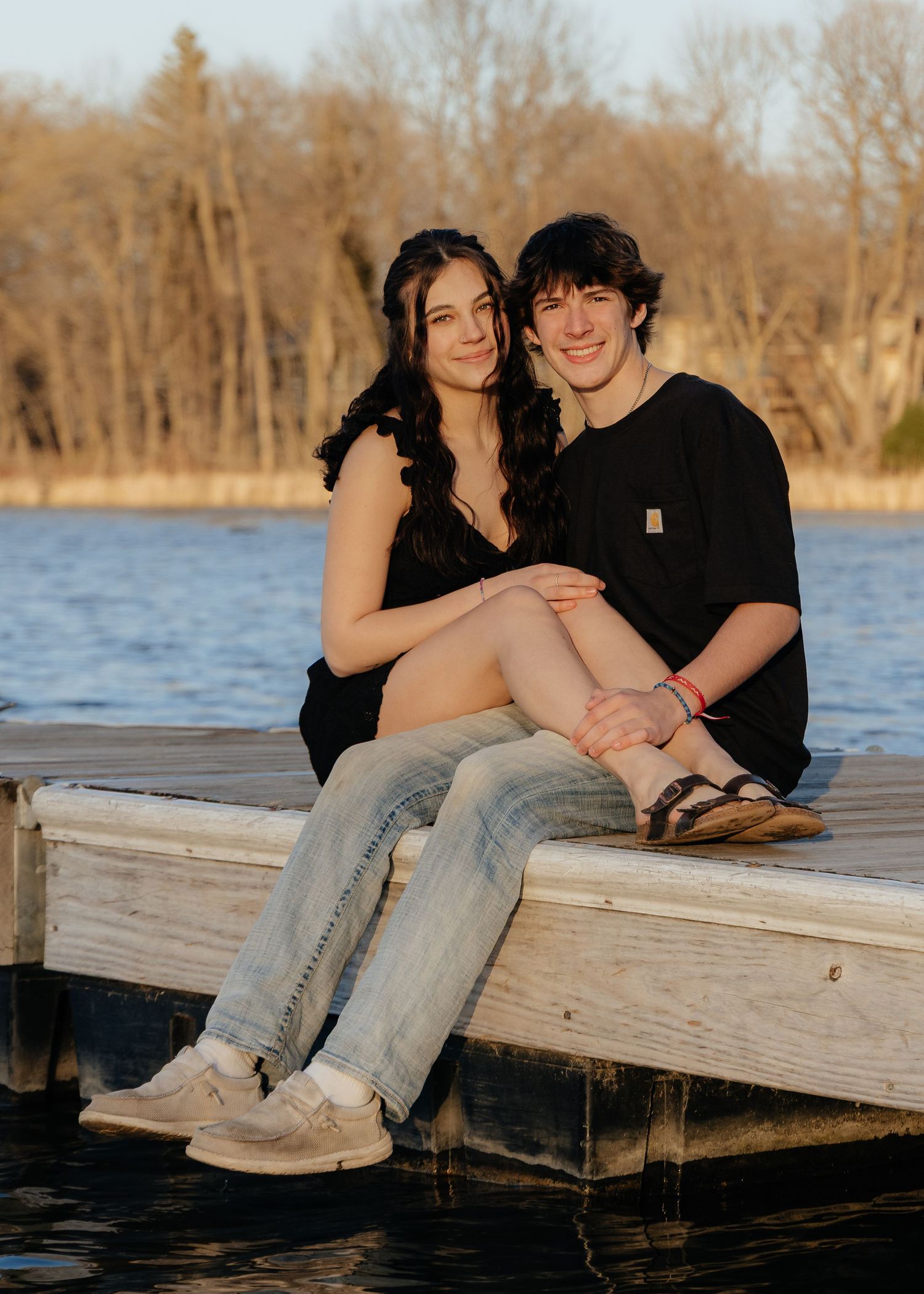 Couple laughing enjoying the blooming trees at Fish Lake Regional Park in Maple Grove, MN, with fresh green grass and soft spring sunlight