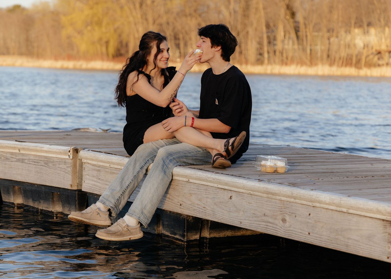 Couple laughing enjoying the blooming trees at Fish Lake Regional Park in Maple Grove, MN, with fresh green grass and soft spring sunlight