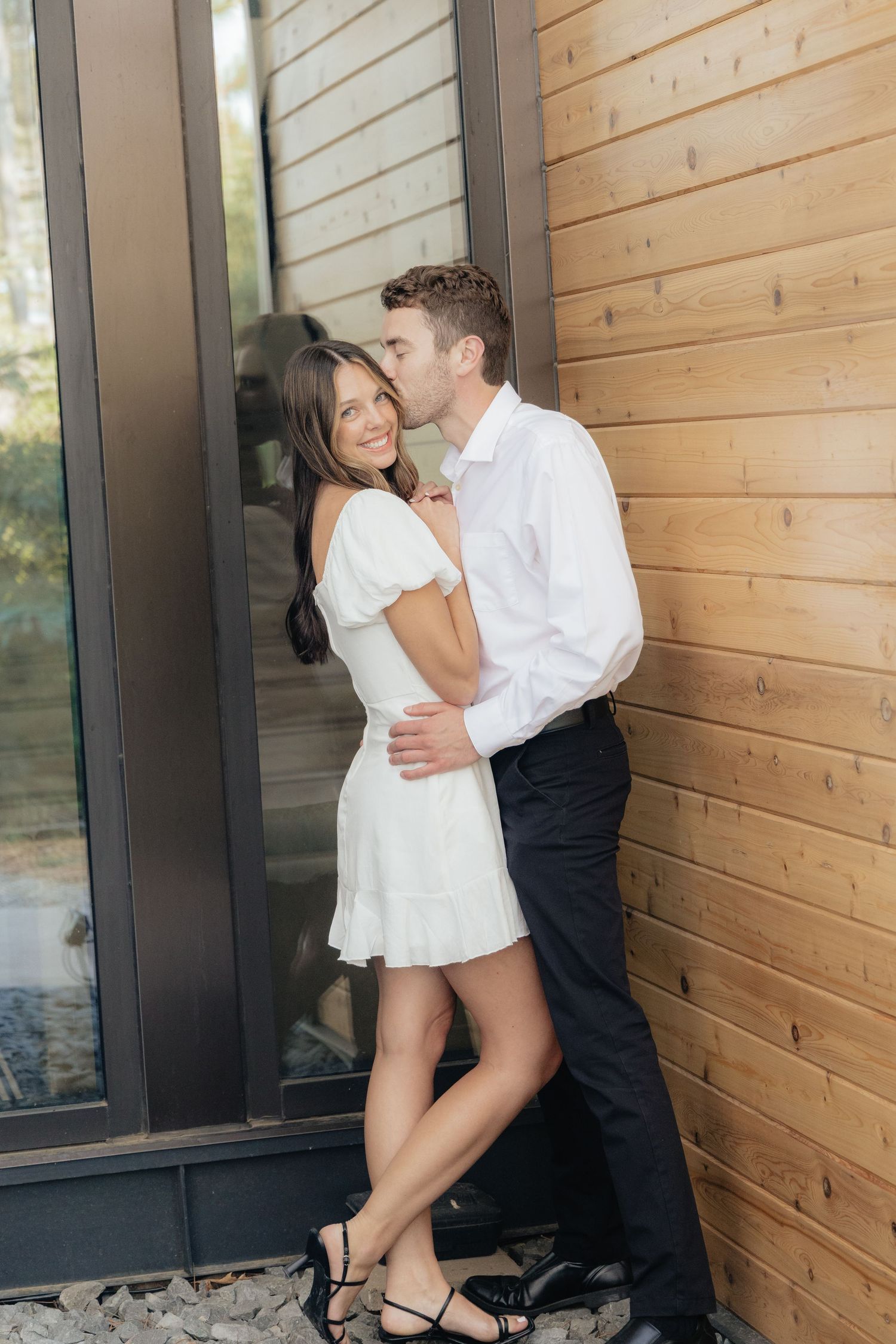 Moody and romantic couples photo with the Pinewood venue softly blurred in the background, highlighting emotion and connection.