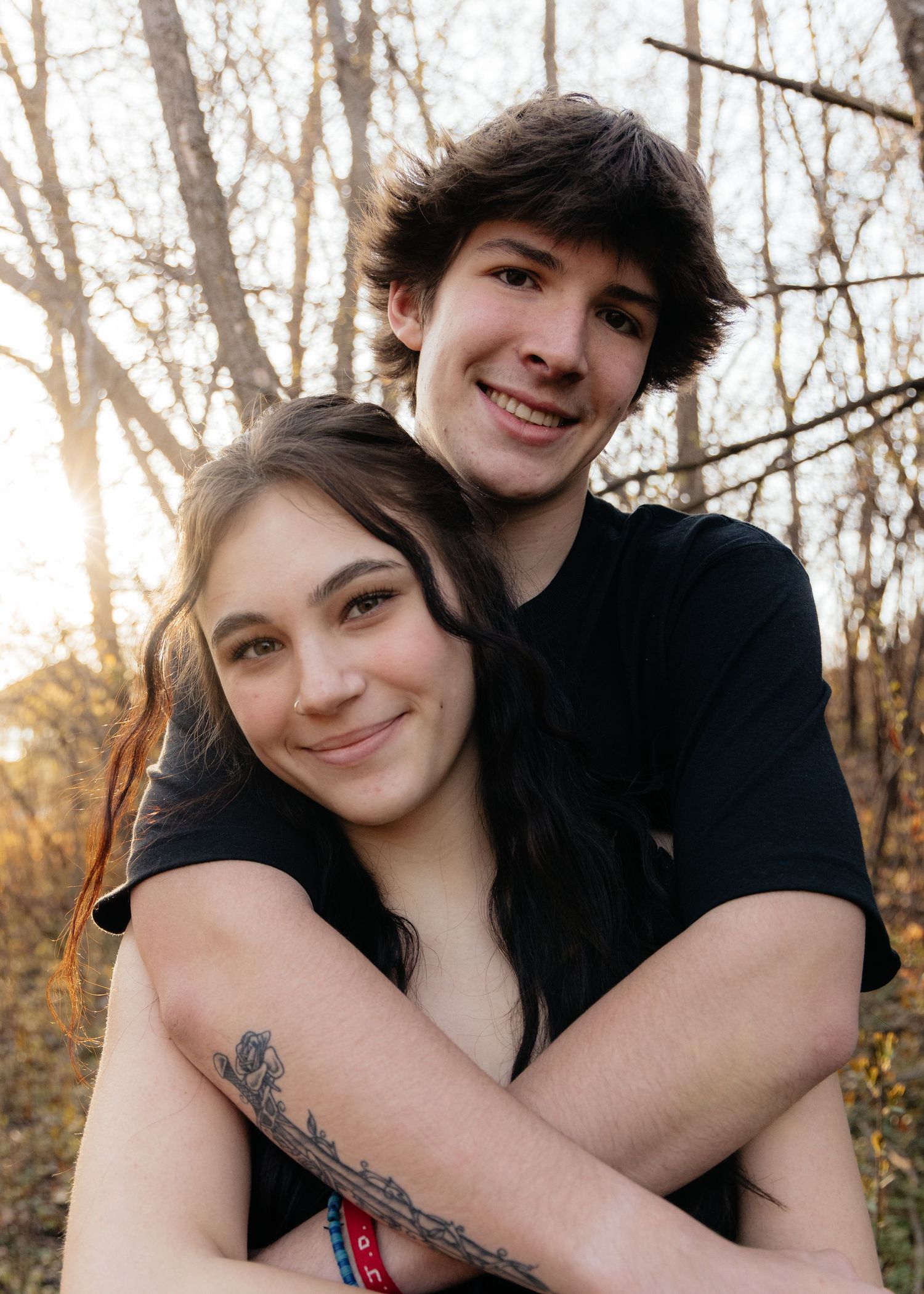 Couple laughing enjoying the blooming trees at Fish Lake Regional Park in Maple Grove, MN, with fresh green grass and soft spring sunlight