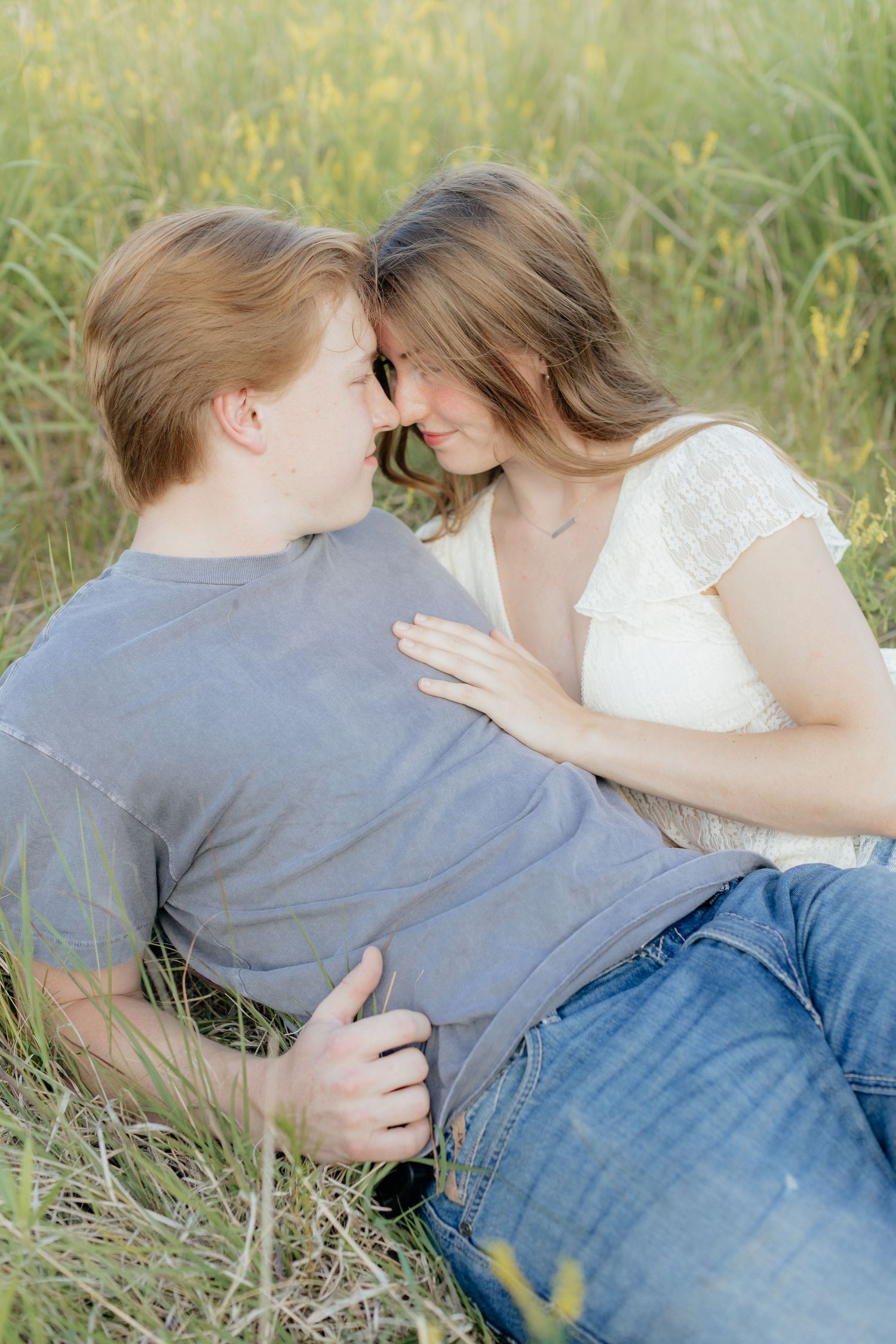 Romantic photo of a couple embracing on a hilltop at Prairie Bluffs, surrounded by open fields and wide Minnesota skies.