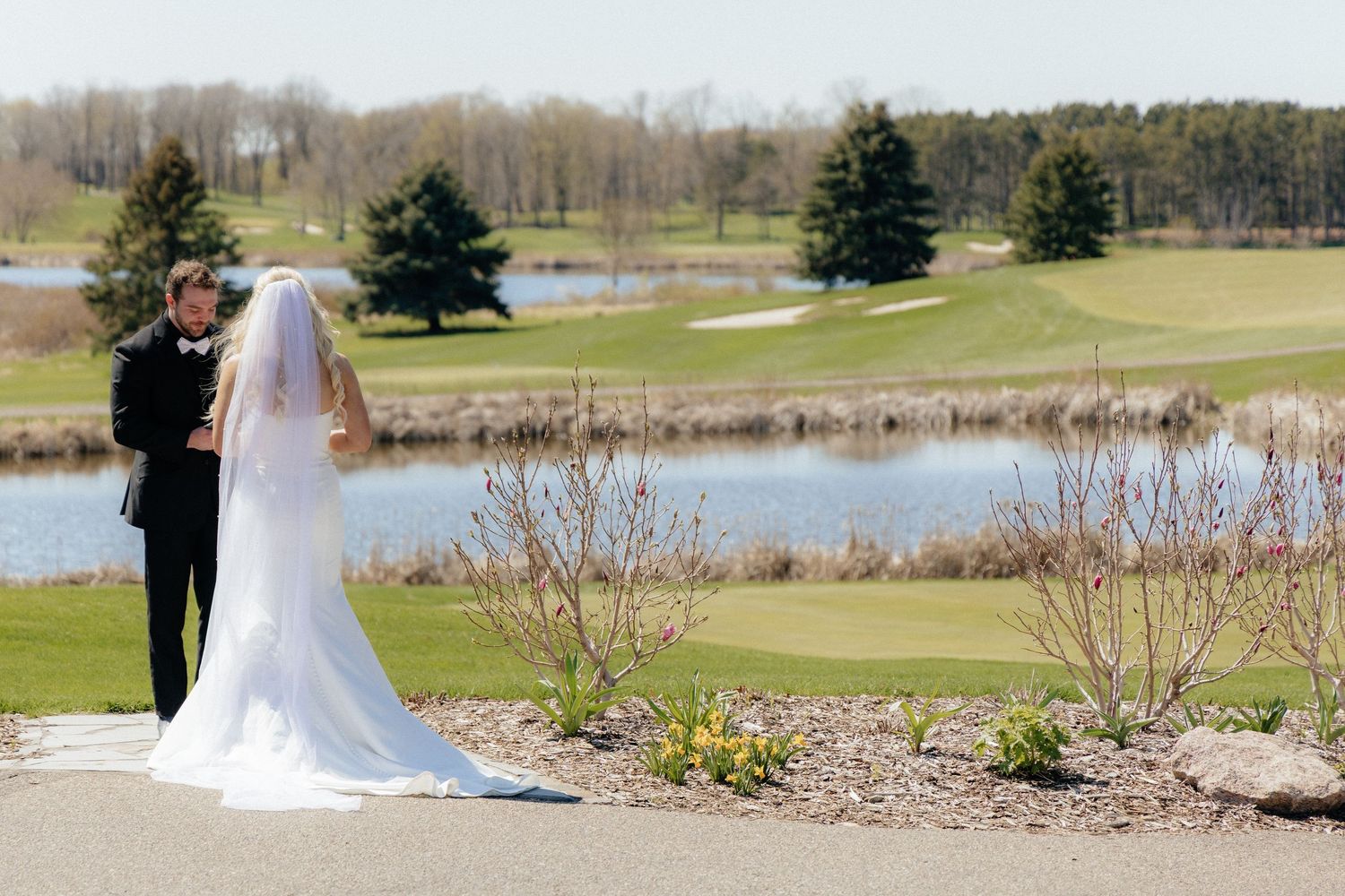 Bride and groom sharing a romantic moment at Rush Creek Golf Course in Maple Grove, MN, with rolling fairways and elegant floral decor