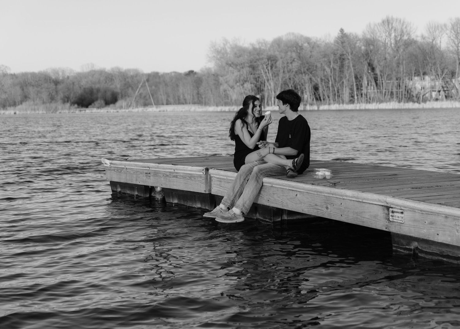 Couple laughing enjoying the blooming trees at Fish Lake Regional Park in Maple Grove, MN, with fresh green grass and soft spring sunlight
