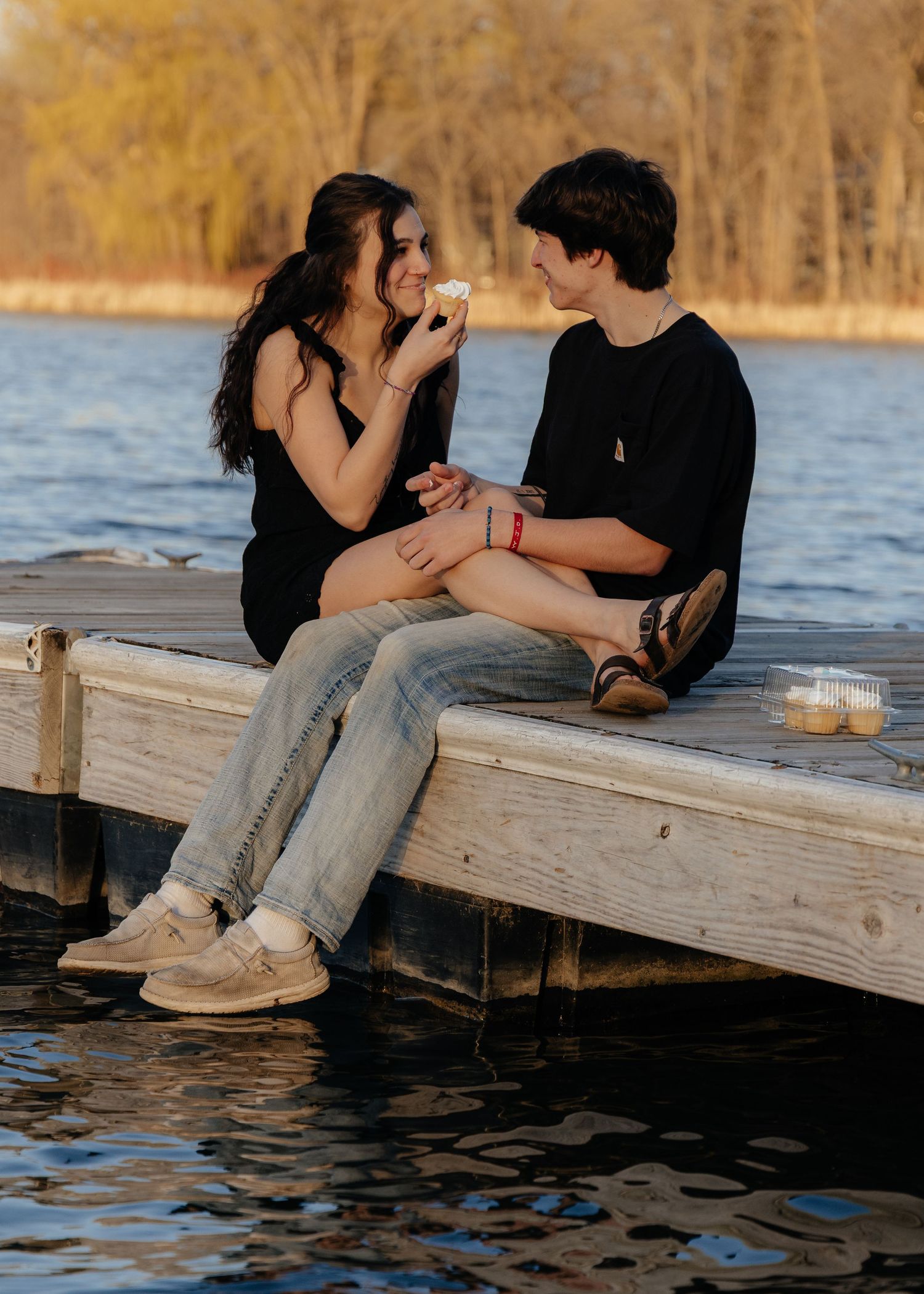 Couple laughing enjoying the blooming trees at Fish Lake Regional Park in Maple Grove, MN, with fresh green grass and soft spring sunlight