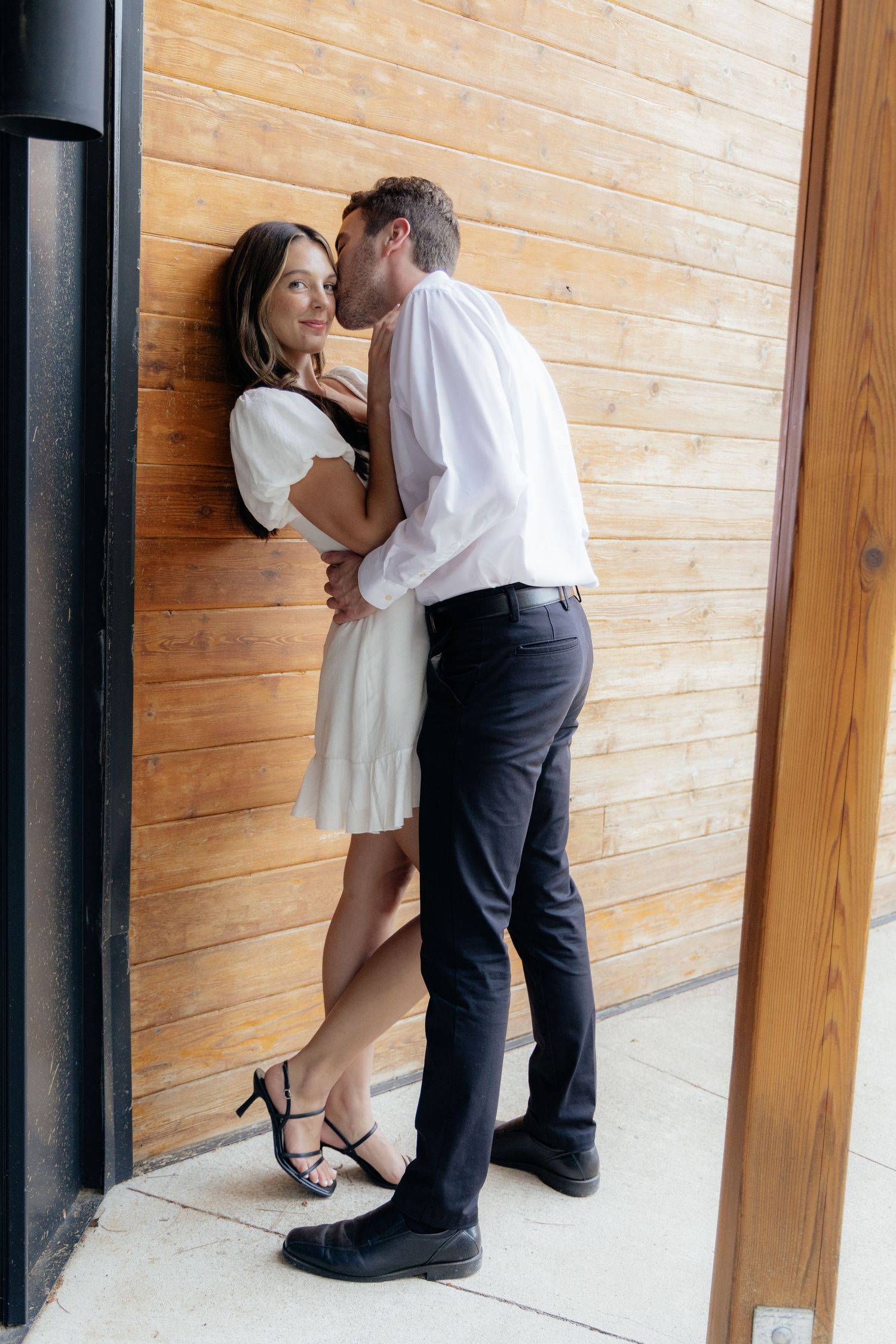 Moody and romantic couples photo with the Pinewood venue softly blurred in the background, highlighting emotion and connection.
