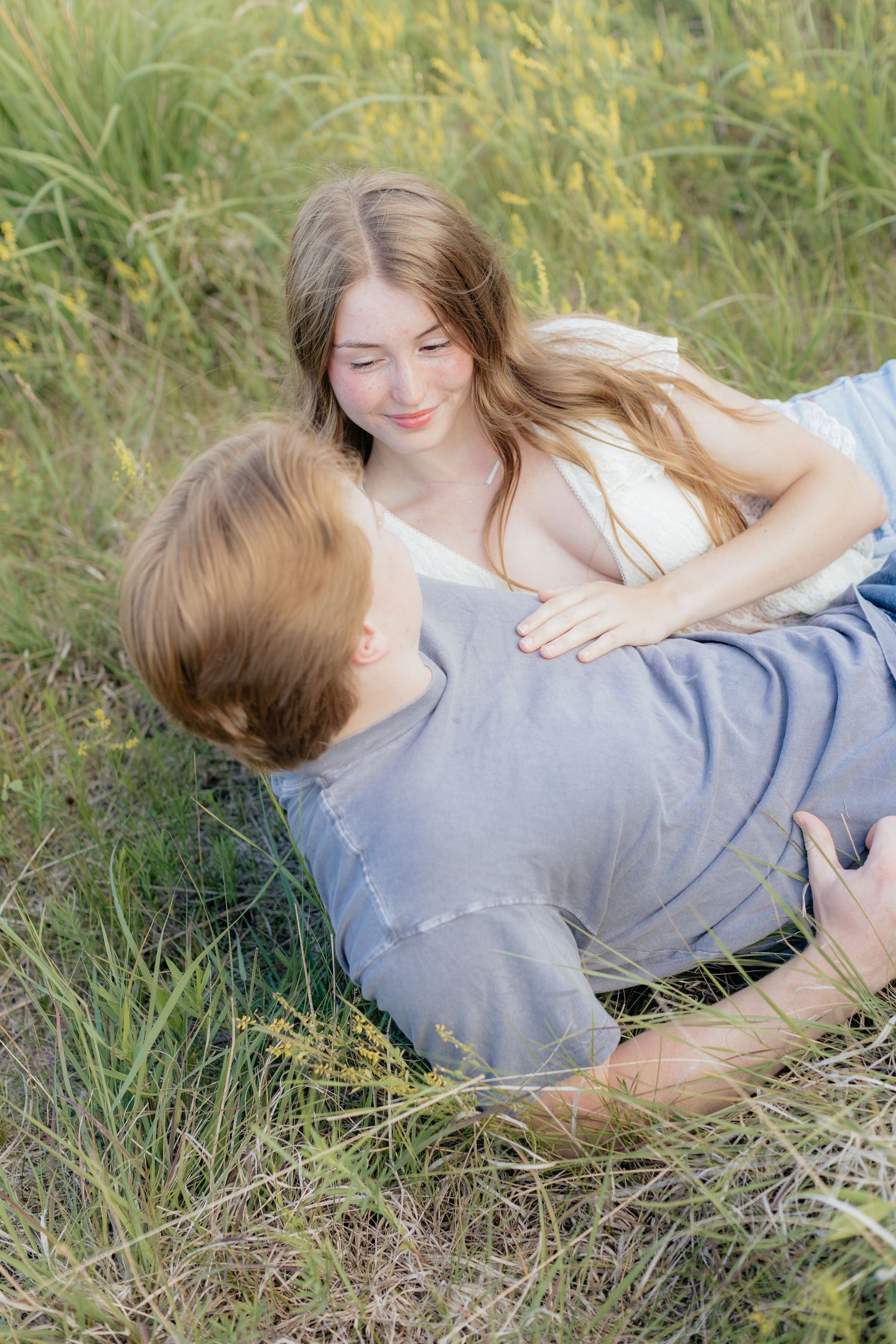 Romantic photo of a couple embracing on a hilltop at Prairie Bluffs, surrounded by open fields and wide Minnesota skies.