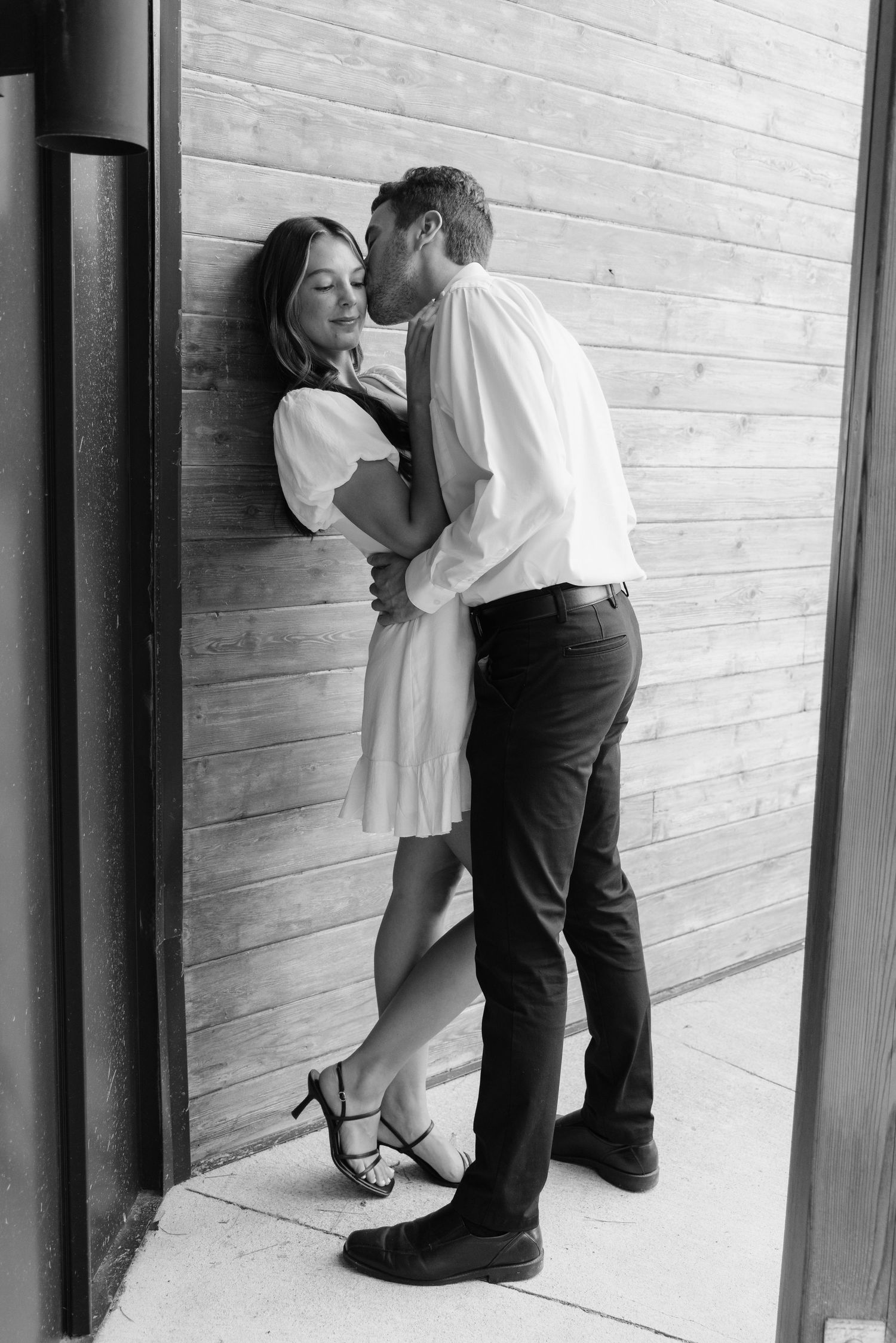 Moody and romantic couples photo with the Pinewood venue softly blurred in the background, highlighting emotion and connection.