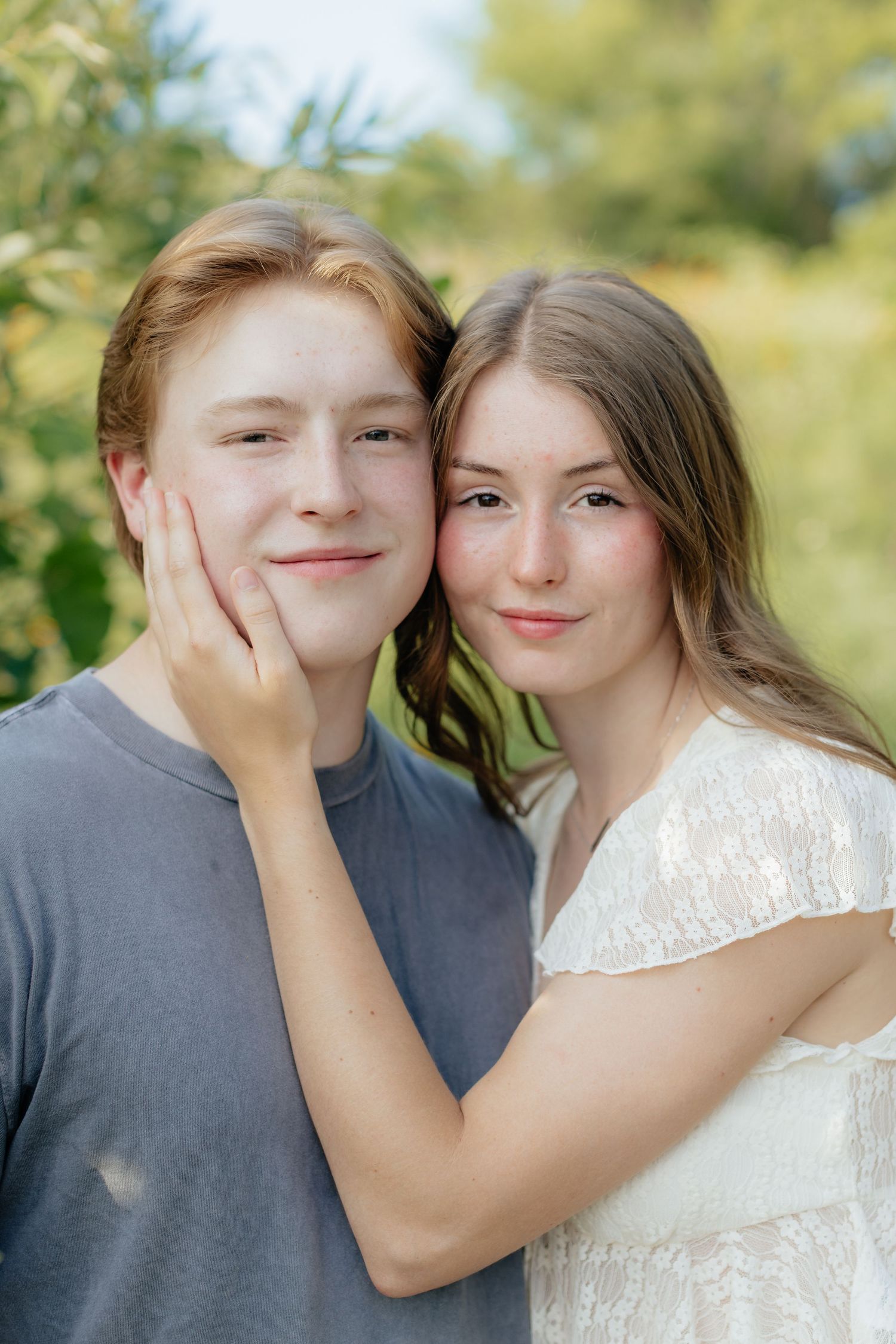 Romantic photo of a couple embracing on a hilltop at Prairie Bluffs, surrounded by open fields and wide Minnesota skies.