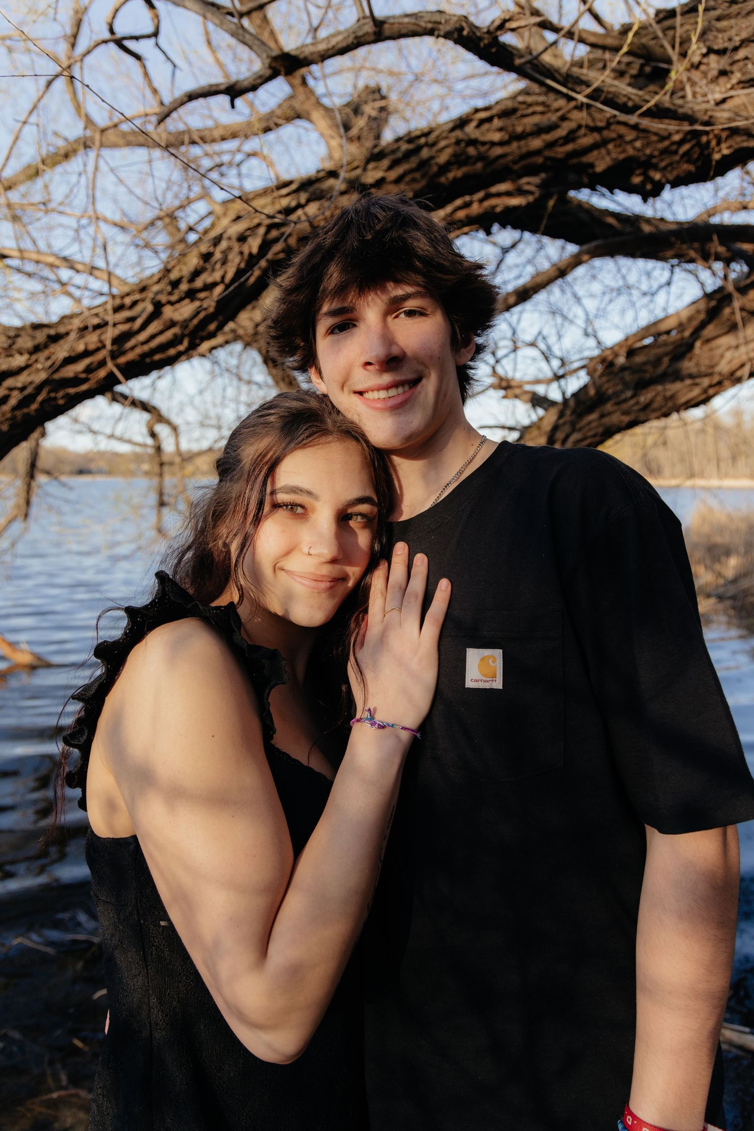 Couple laughing enjoying the blooming trees at Fish Lake Regional Park in Maple Grove, MN, with fresh green grass and soft spring sunlight