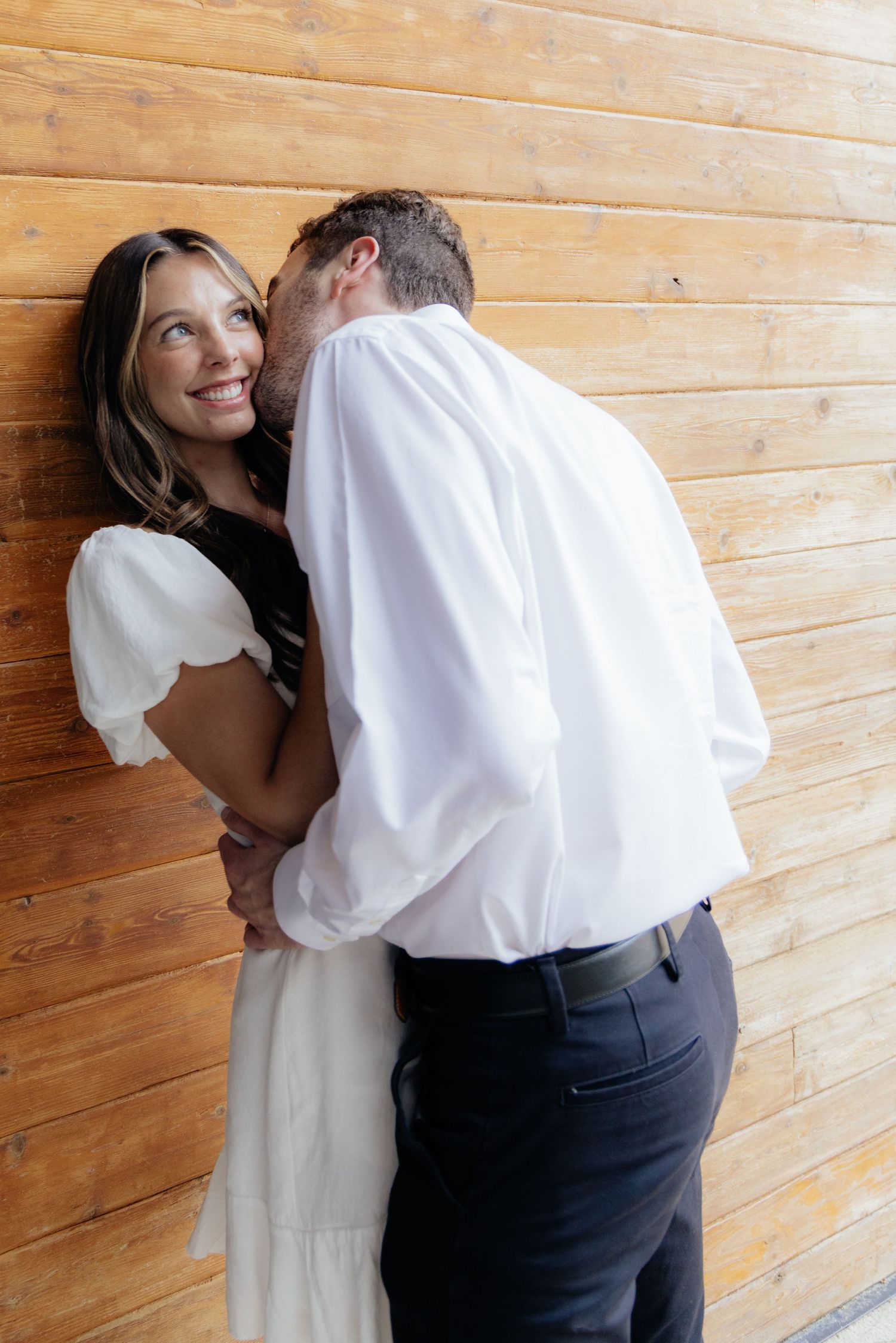 Moody and romantic couples photo with the Pinewood venue softly blurred in the background, highlighting emotion and connection.