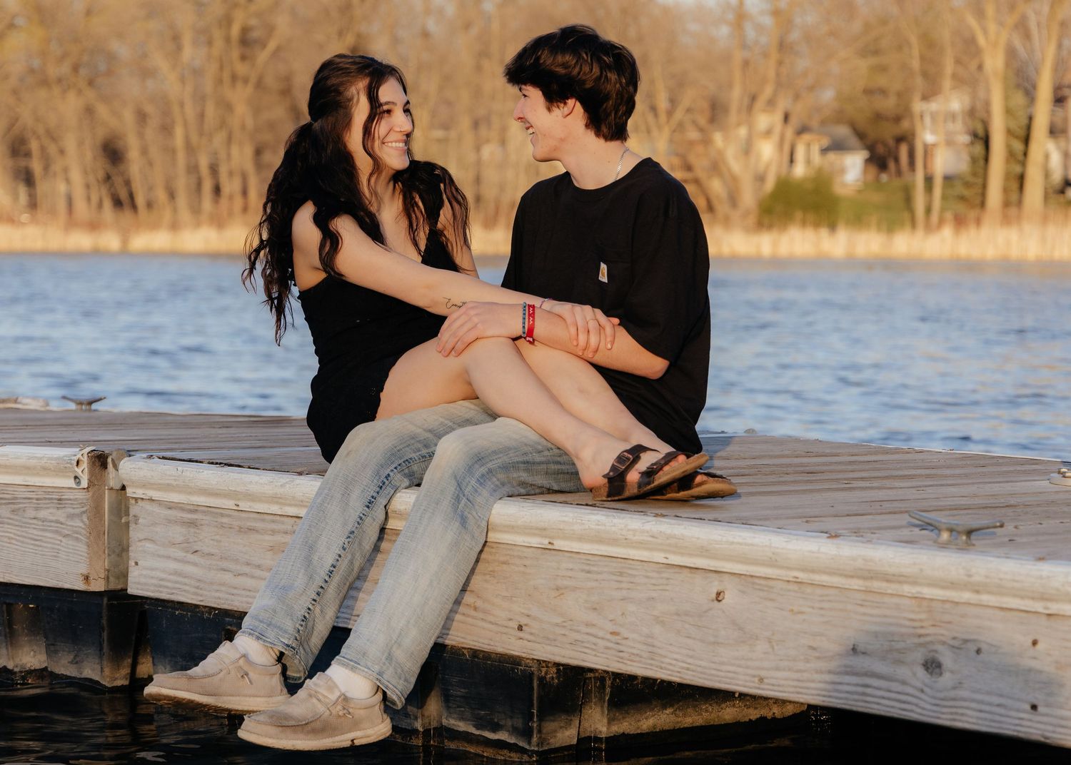 Couple laughing enjoying the blooming trees at Fish Lake Regional Park in Maple Grove, MN, with fresh green grass and soft spring sunlight