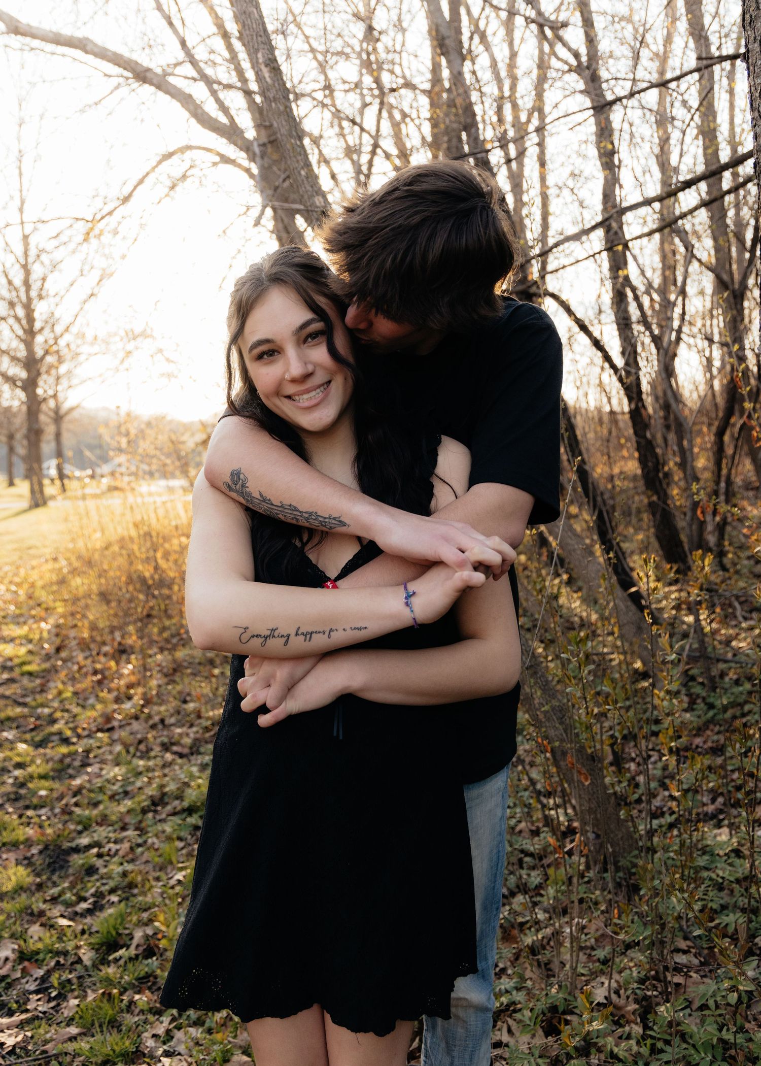 Couple laughing enjoying the blooming trees at Fish Lake Regional Park in Maple Grove, MN, with fresh green grass and soft spring sunlight