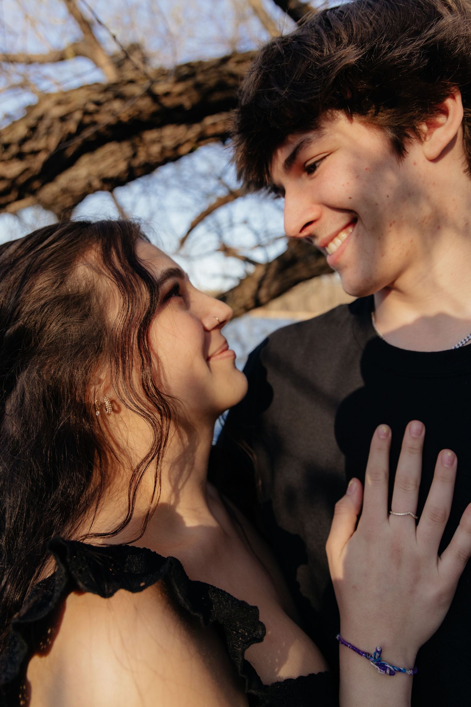 Couple laughing enjoying the blooming trees at Fish Lake Regional Park in Maple Grove, MN, with fresh green grass and soft spring sunlight