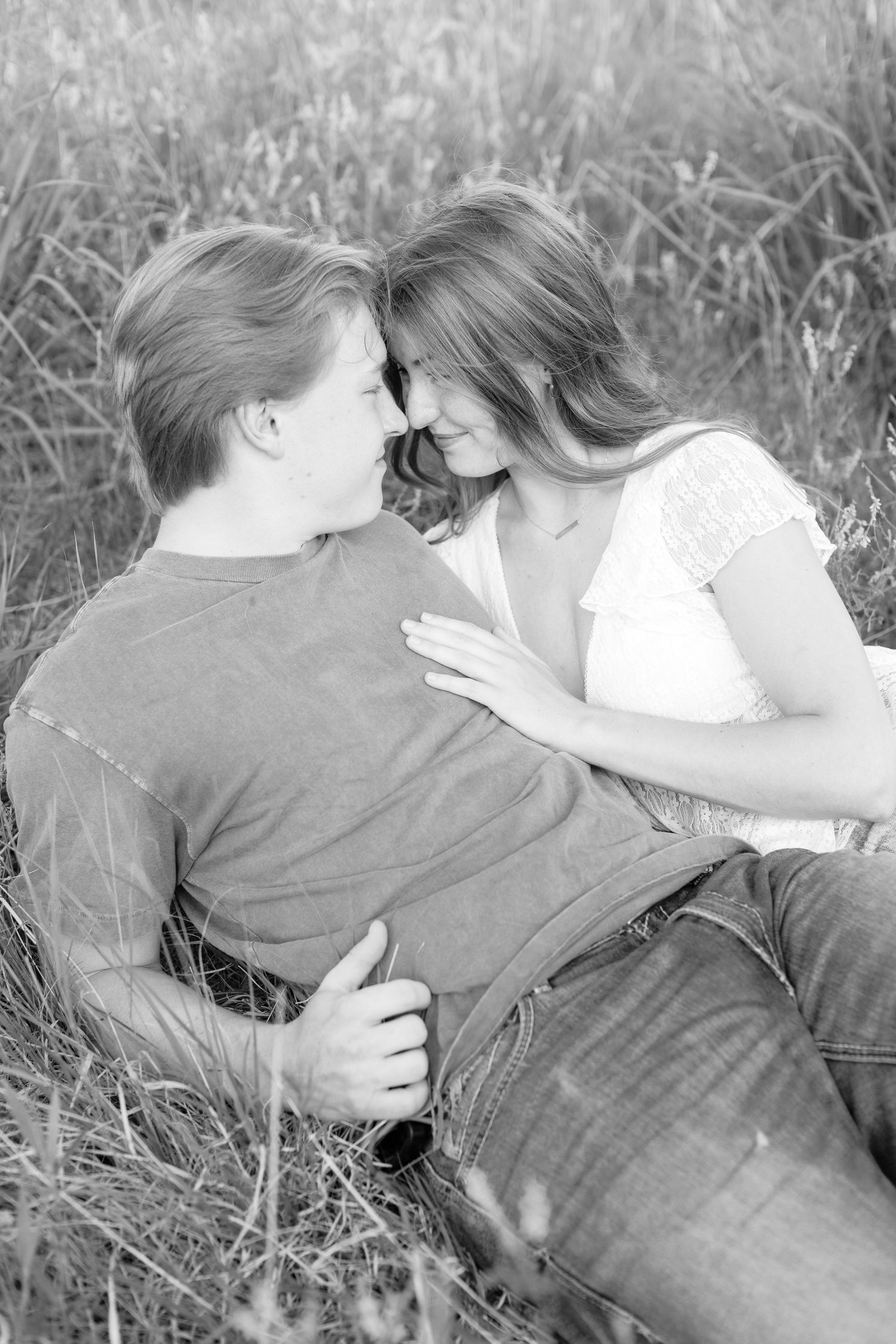 Romantic photo of a couple embracing on a hilltop at Prairie Bluffs, surrounded by open fields and wide Minnesota skies.