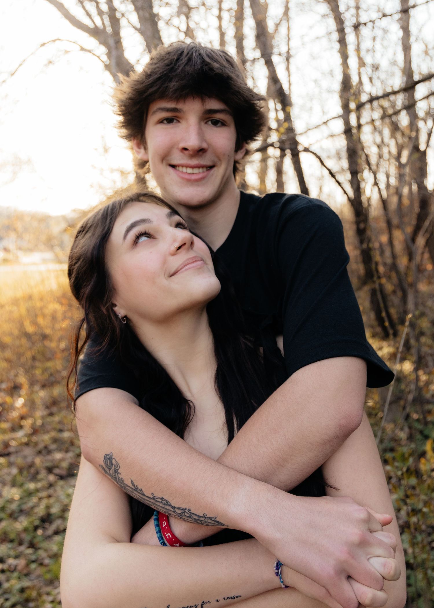 Couple laughing enjoying the blooming trees at Fish Lake Regional Park in Maple Grove, MN, with fresh green grass and soft spring sunlight