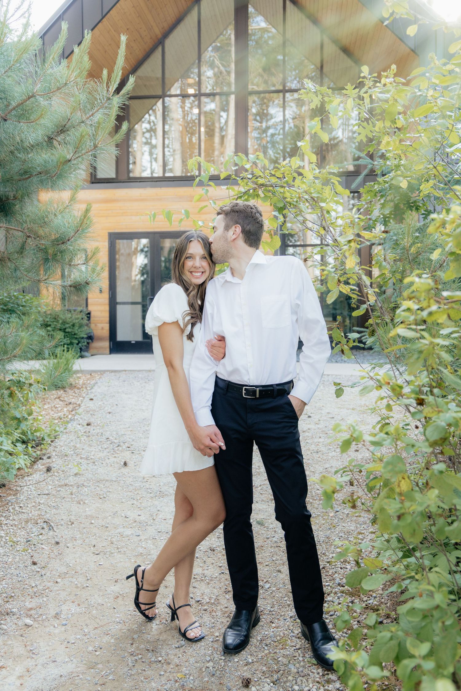 Moody and romantic couples photo with the Pinewood venue softly blurred in the background, highlighting emotion and connection.