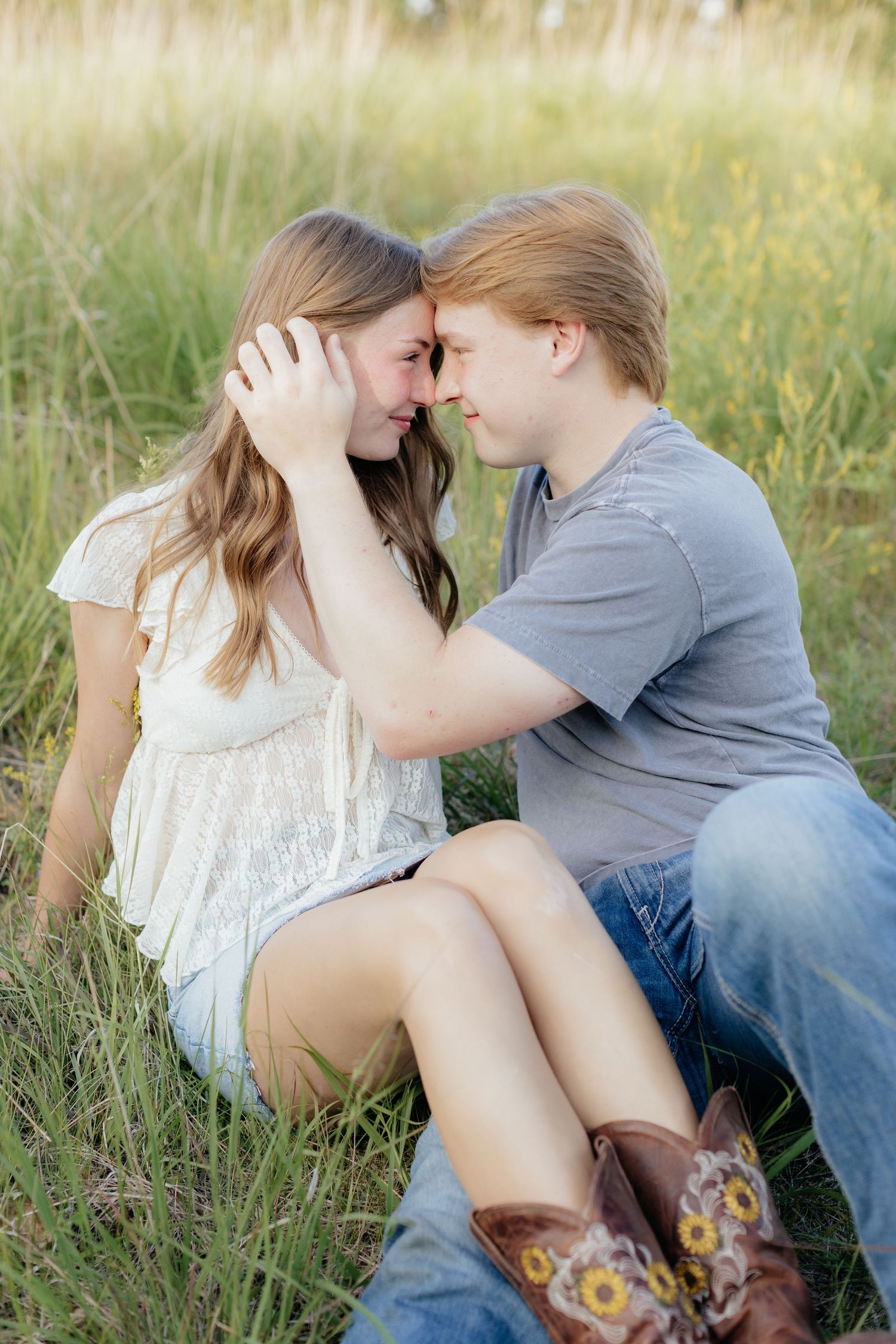 Romantic photo of a couple embracing on a hilltop at Prairie Bluffs, surrounded by open fields and wide Minnesota skies.