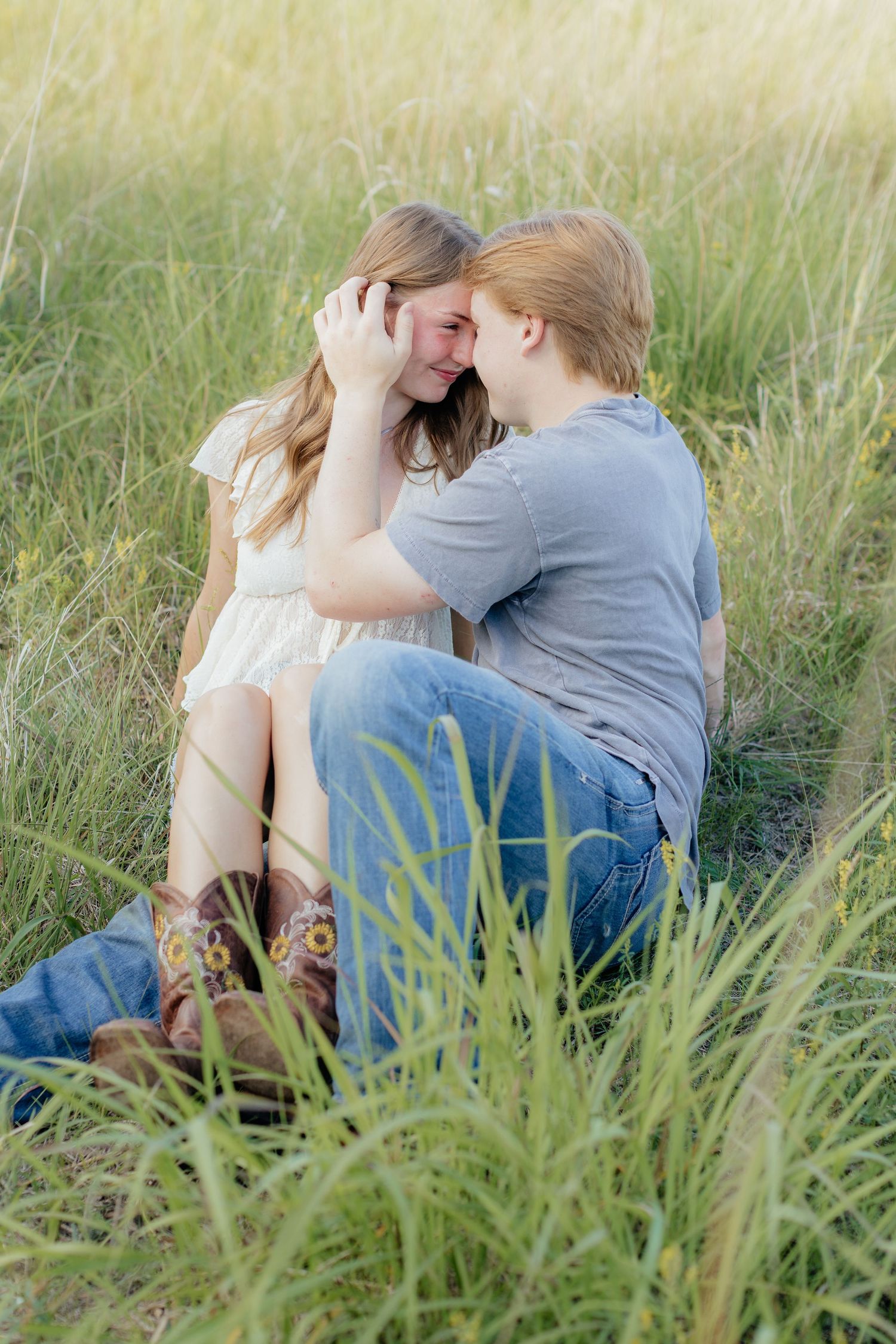 Romantic photo of a couple embracing on a hilltop at Prairie Bluffs, surrounded by open fields and wide Minnesota skies.
